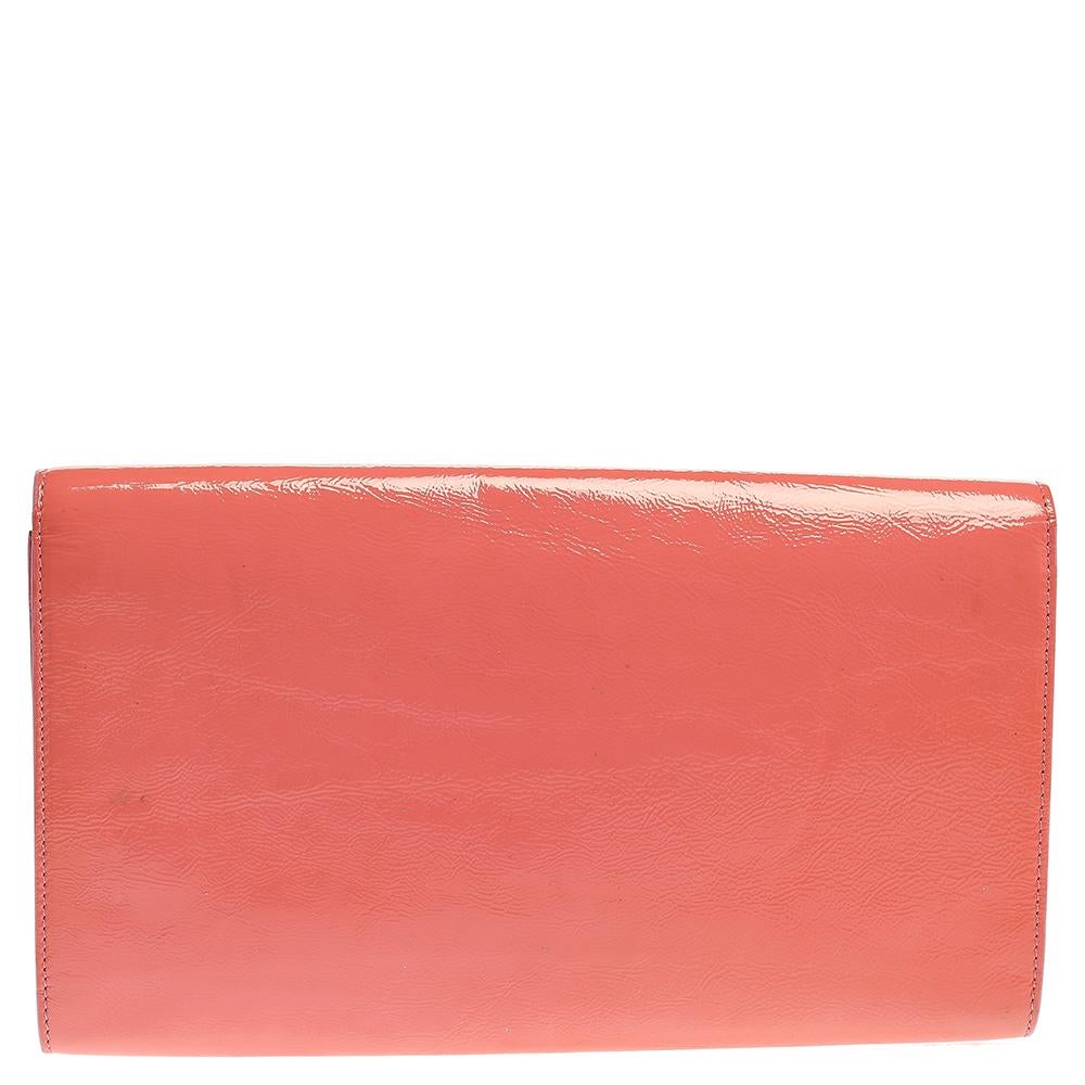 The Belle de Jour clutch by Saint Laurent is a creation that is not only stylish but also exceptionally well-made. Meticulously crafted from patent leather, it flaunts a pink shade and a YSL-stitched flap that leads to a satin interior. High on