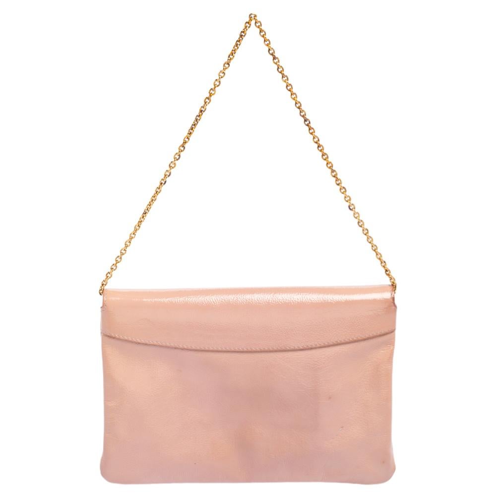 Saint Laurent is known for perfection and this piece is no different. This clutch made from pink patent leather features a chain handle. It has a flap closure with the brand's logo on it and a mirror on the inside. This splendid creation goes well