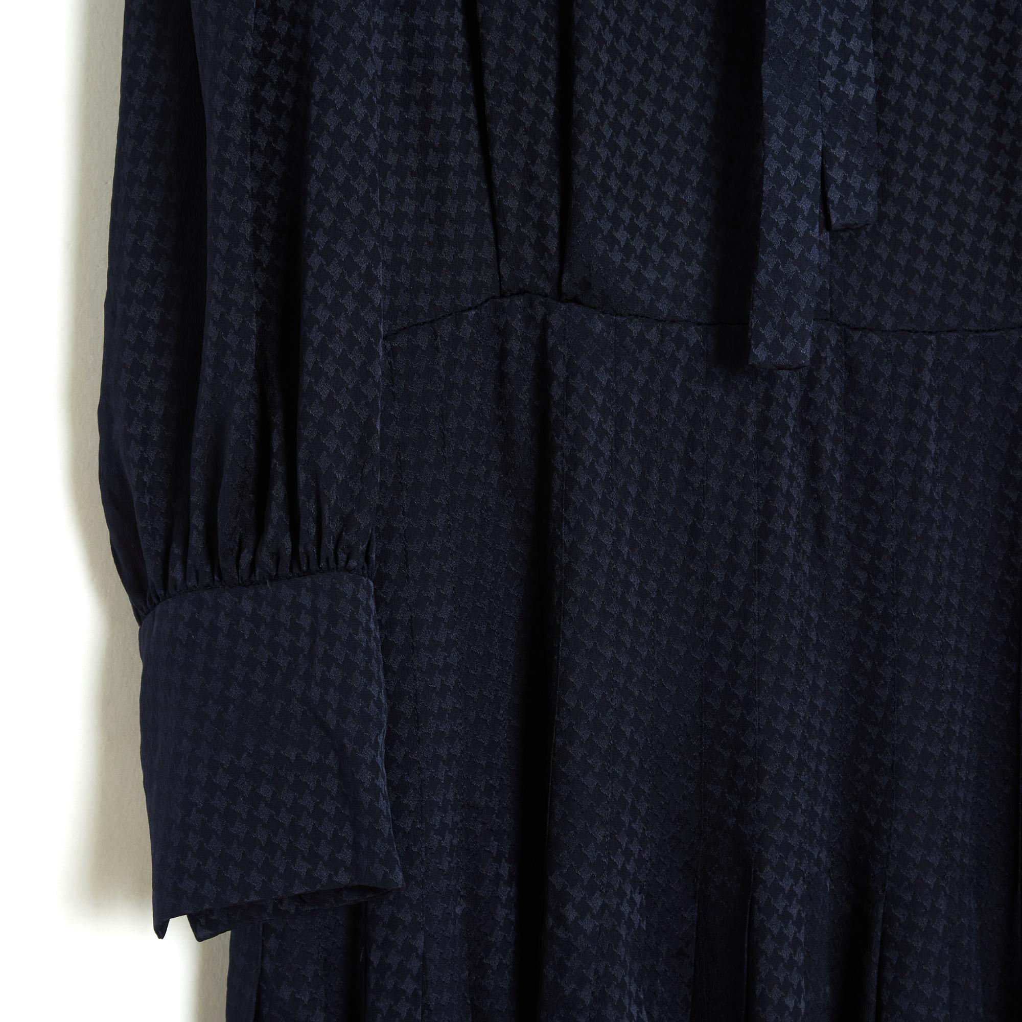 Saint Laurent Pre Fall 2020 collection dress by Anthony Vacarello in navy blue silk satin damask in a houndstooth pattern, ruffled collar closed by a lavallière and 6 buttons over the entire height of the bust, pleated skirt stitched on the hips,