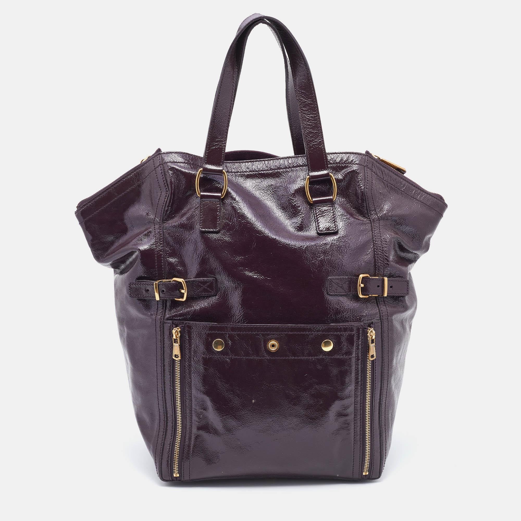 This gorgeous Downtown tote comes from the House of Saint Laurent. It is crafted from purple leather on the exterior. It features two handles, gold-toned hardware, and a suede-lined interior. This stunning creation is ideal for everyday use.

