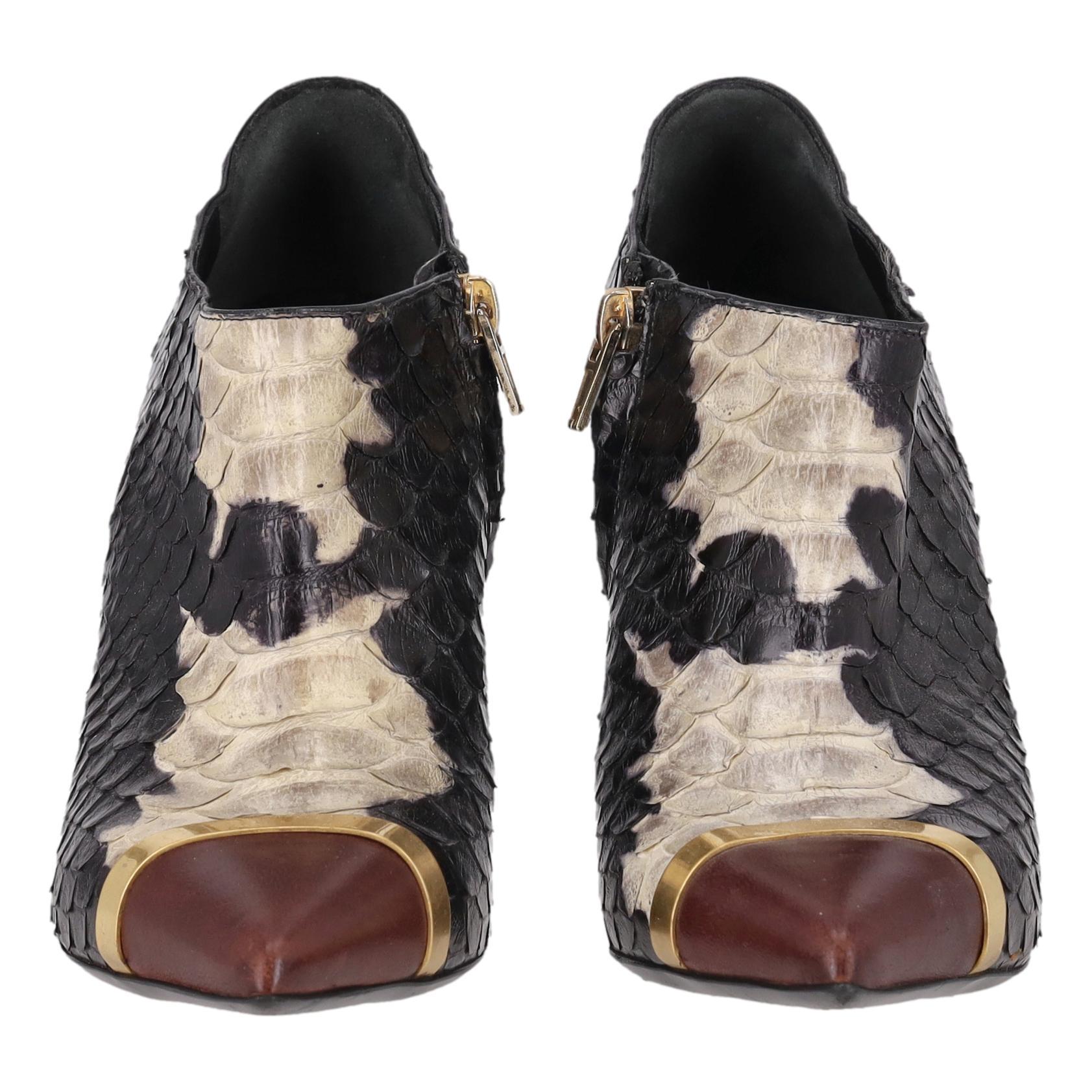 Saint Laurent Python Skin Ankle Boots

Black ankle boots crafted from exotic python skin with light grey details along the front.

Detailed with a smooth burgundy leather pointed toe with a gold trim.

Featuring a high stiletto heel and a zip