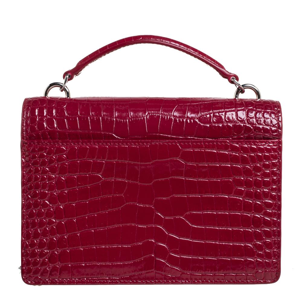 Fall in love with this Sunset bag from Saint Laurent! Crafted from croc-embossed leather, it flaunts the 'YSL' logo on the front flap in silver-tone metal. It has a spacious leather and fabric-lined interior that houses pockets. This red beauty is