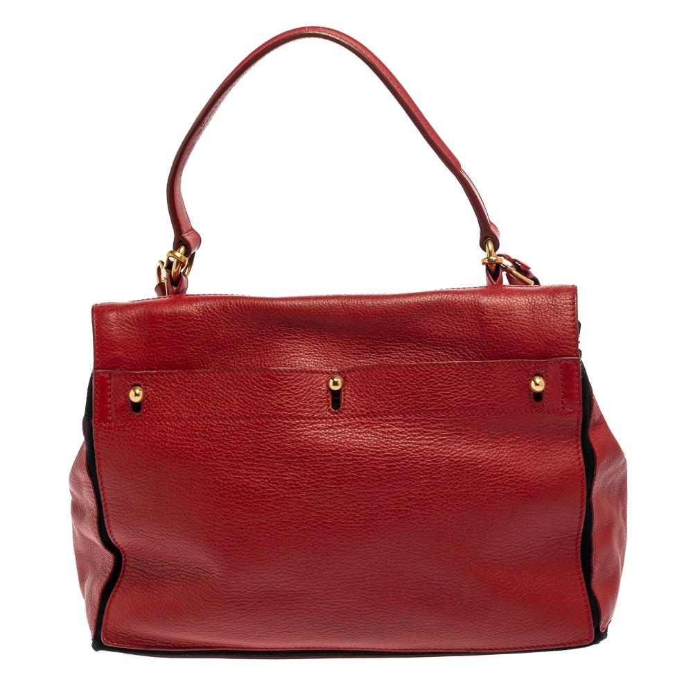 Make everyone nod in approval when you step out swaying this Saint Laurent bag. It has been crafted from red leather and canvas trims and held by a single top handle. It flaunts a lock on the front flap that leads to a spacious canvas interior. It