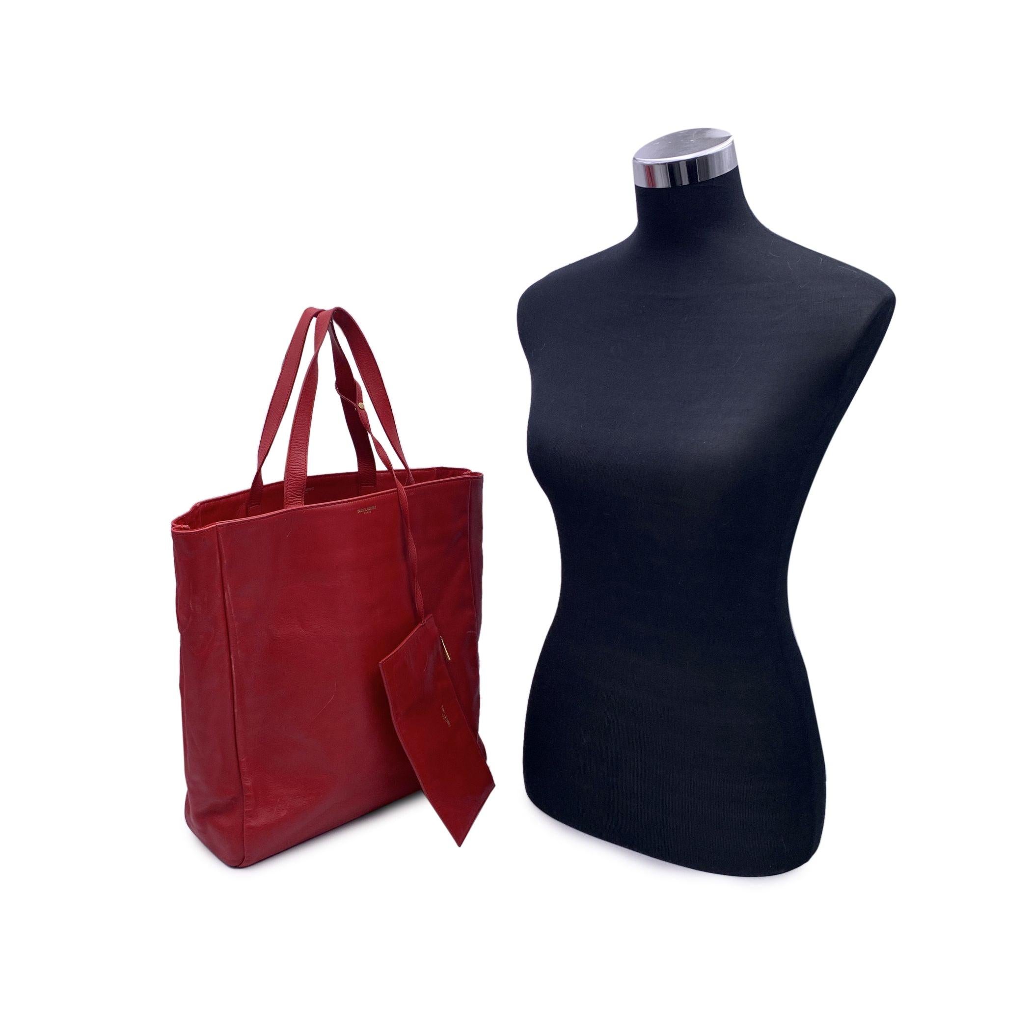 Beautiful Saint Laurent red leather North South Reversible Shopping tote bag. Suede with leather accents reverses to smooth leather. Open top. Double flat straps. Removable zip-top pouch attaches. Gold metal Saint Laurent logo at center front.