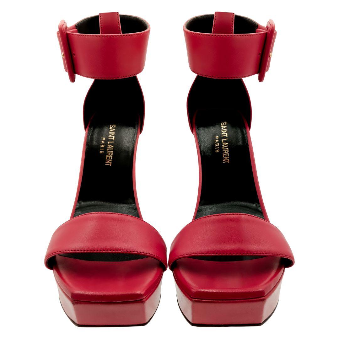 Saint Laurent red platform ankle strap wedge sandals.

Platform angled at the front of the shoe.

Square toe.

Ankle strap with large buckle detail.

Condition Details: In excellent, gently used condition consistent with its age and use. Only worn