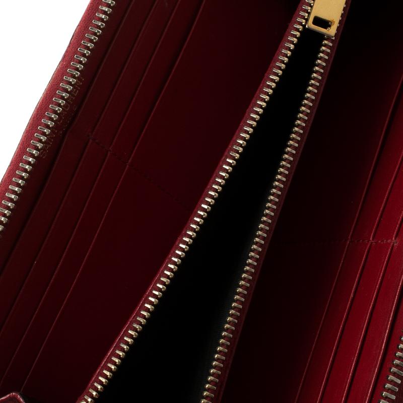 A classic zip around wallet from the fashion house Saint Laurent, this beautiful piece is a stylish essential to add to your collection. Crafted from red textured patent leather, the gold tone brand name lettering at the front and the zipper