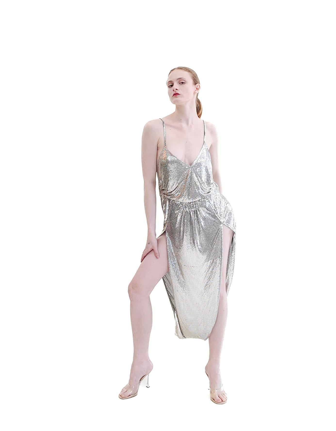 Disegnata con maestria da Saint Laurent, questa tuta NWT in maglia metallica argentata / Chain Mail è caratterizzata da gambe scoperte con un esclusivo orlo a palloncino per un look sorprendente e versatile. Eleva il tuo guardaroba con questa tuta