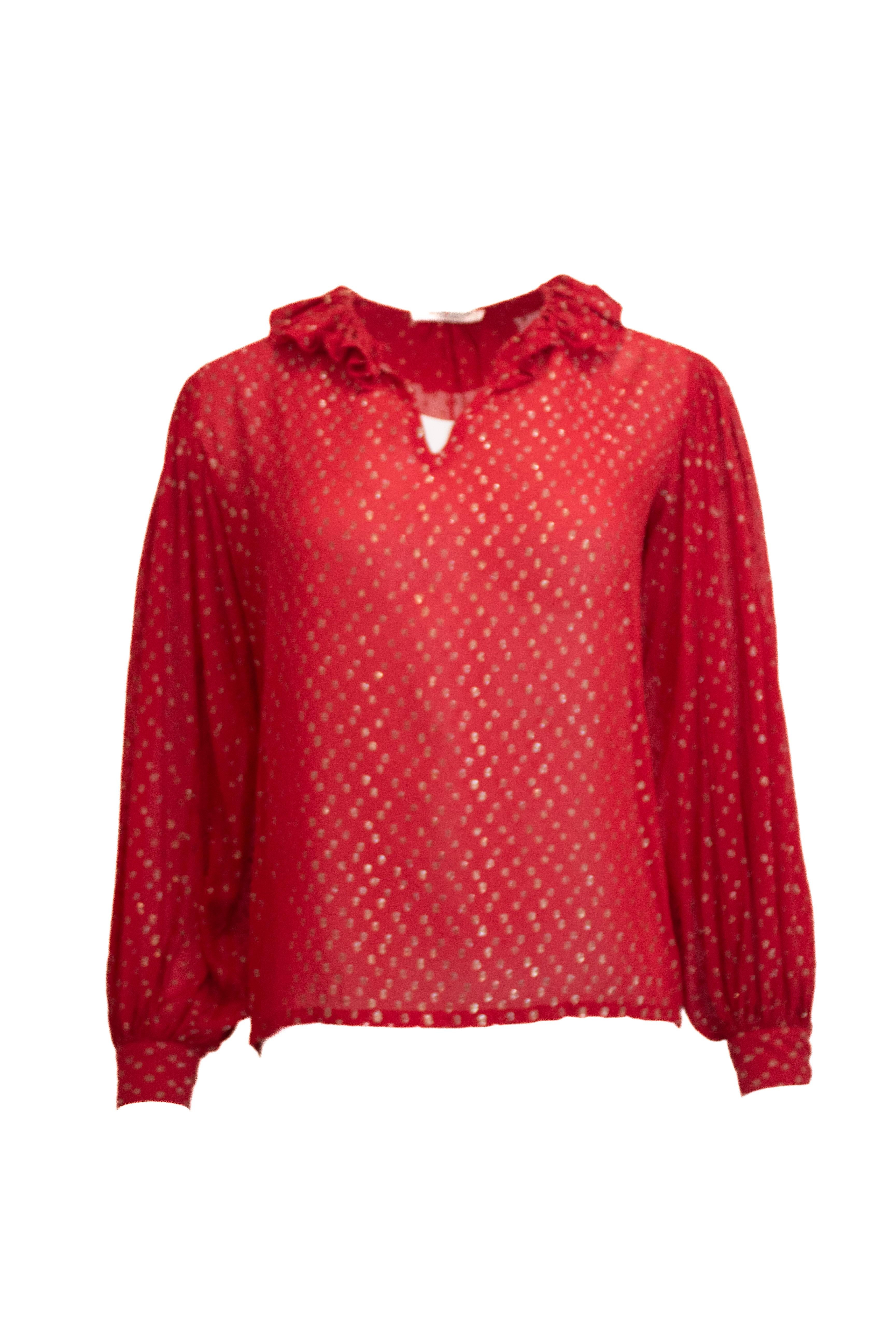 Eleva il tuo guardaroba con questa blusa vintage di Yves Saint Laurent realizzata in lussuosa seta svizzera a pois rossi. Il tessuto trasparente e il delicato colletto a balze aggiungono una consistenza e un'eleganza raffinate, rendendolo un capo