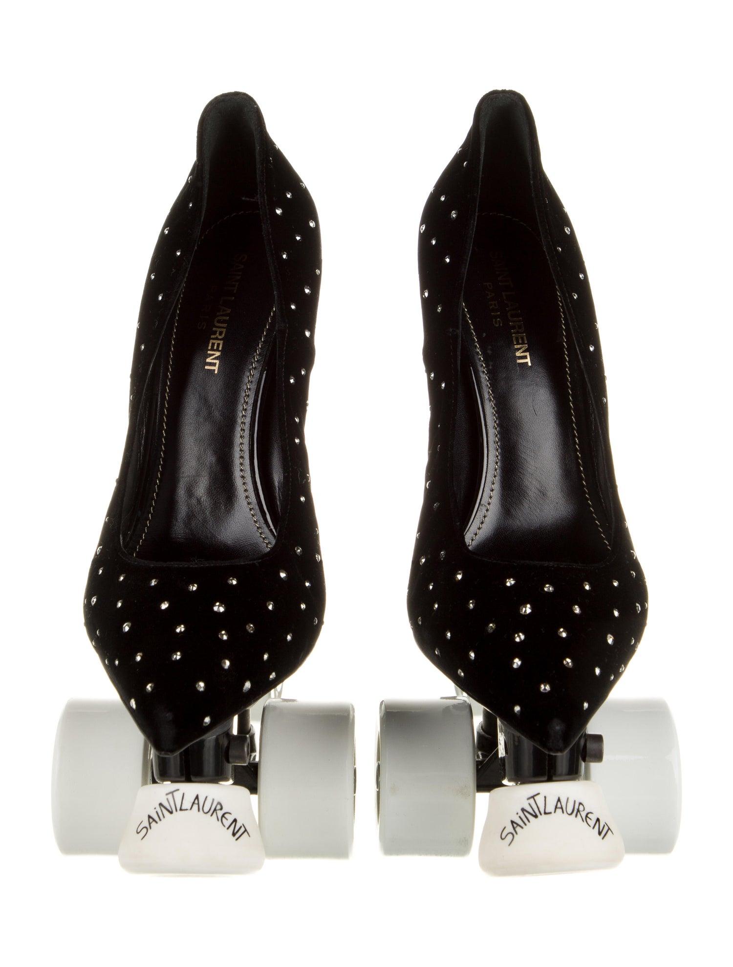 SAINT LAURENT
Pair of black satin Saint Laurent Roller Skate Stiletto decorative objects with white crystal embellishments throughout, silver-tone metal hardware, white plastic wheels at underside, brand logo at front and brand stamp at interior.