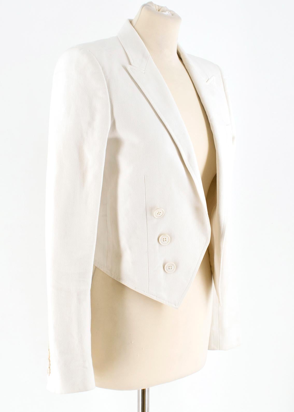 Saint Laurent Runway cropped white blazer

- White, cotton drill 
- Peak lapels, long sleeves
- Heavily padded shoulders, decorative buttons on cuffs 
- Single chest welt pockets
- Angular hem 
- Open front, decorative double breasted fastening 
-