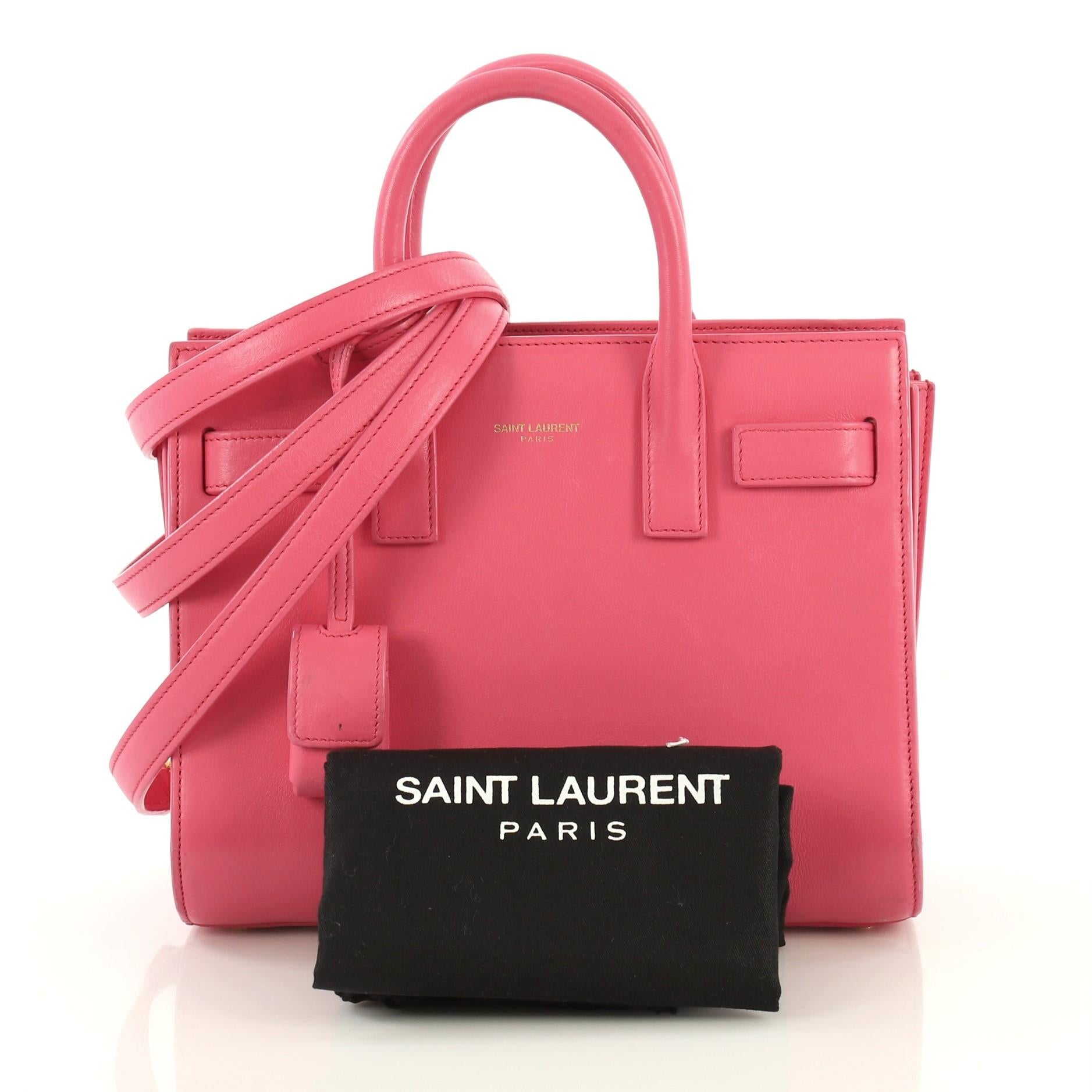 This Saint Laurent Sac de Jour Bag Leather Nano, crafted from pink leather, features dual rolled leather handles, protective base studs, and gold-tone hardware. Its leather tabs open to a pink suede interior with side slip pocket. 

Estimated Retail