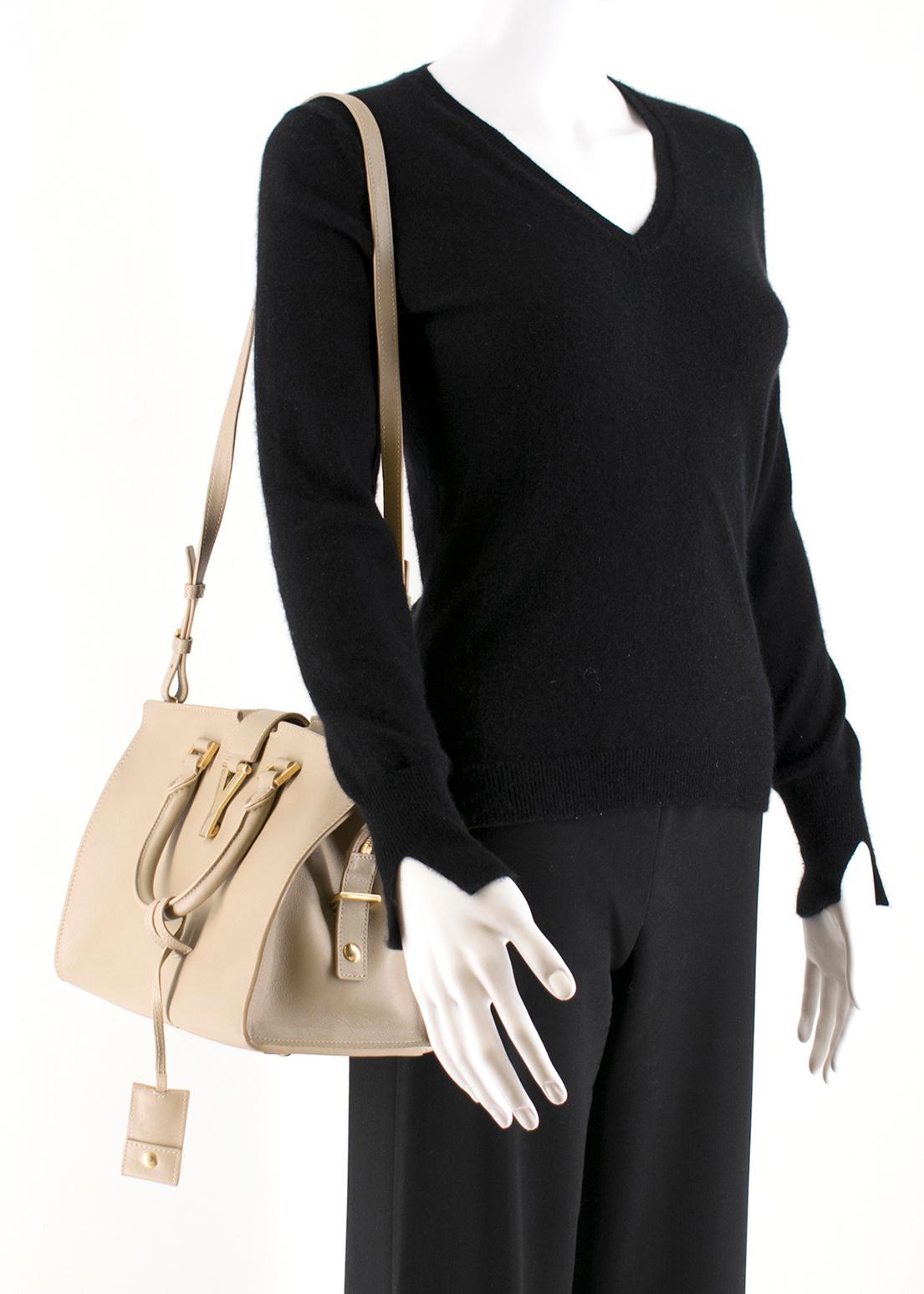 The Sac Ligne Y Bag is the perfect medium sized bag for day or evening essentials. It features a magnetic snap closure with a weighted gold Y logo, rolled leather top handles with gold links, stitched Yves Saint Laurent logo in front and a beige