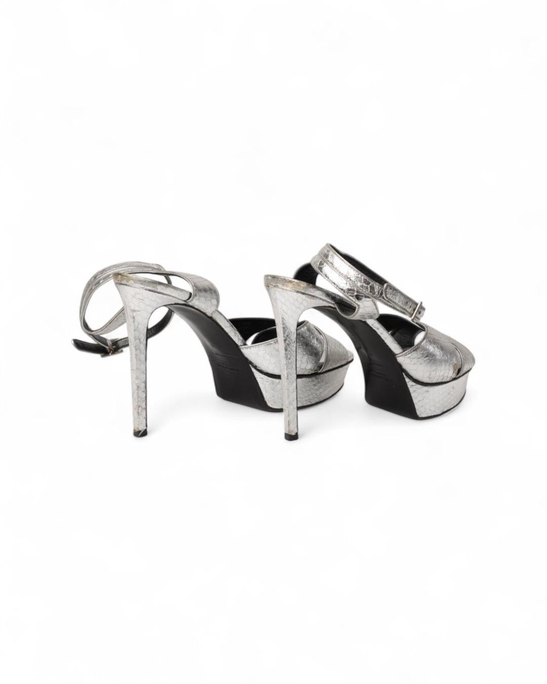 Saint Laurent signature sandal made of leather with python effect and silver hardware. Featuring an adjustable ankle closure, it has a 12.5-centimeter high heel. Number 40 IT. The item is in good condition, with signs of wear visible in