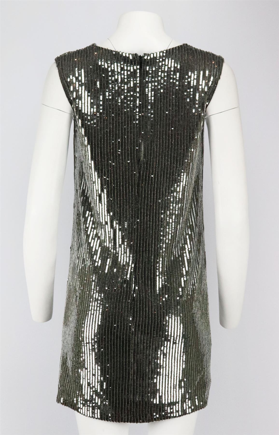 Este minivestido de Saint Laurent está confeccionado en seda ligera con adornos de lentejuelas, y destaca por su escote drapeado y su corte sin mangas. Lentejuelas plateadas, seda negra. Cremallera oculta en la espalda. 100% Seda. Talla: FR 38 (UK