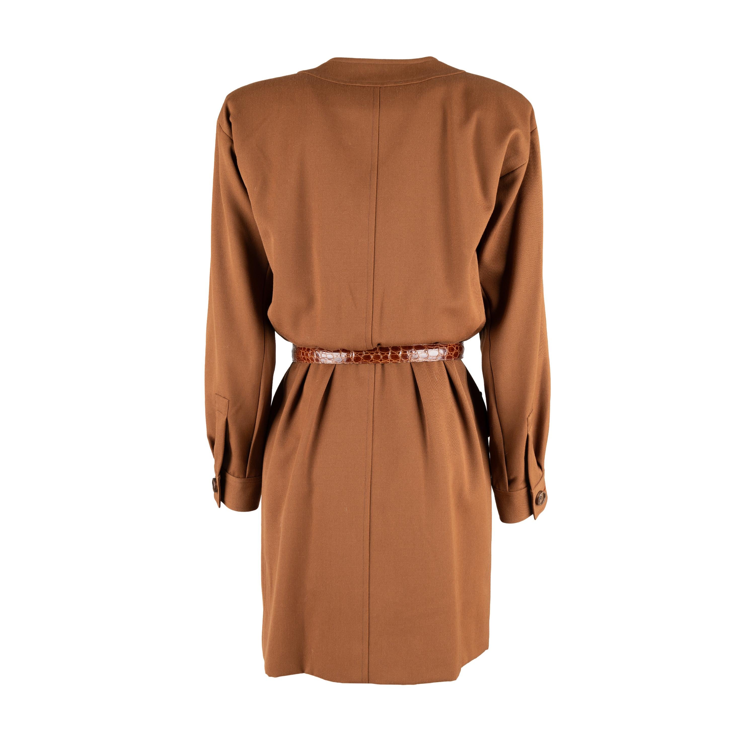 This Saint Laurent Shirt Dress from the 1979 Safari Collection is an iconic design that will never go out of style. Crafted in a heavy brown fabric, it features charming wooden buttons, four front pockets, a round neck, and sleeve cuff. A