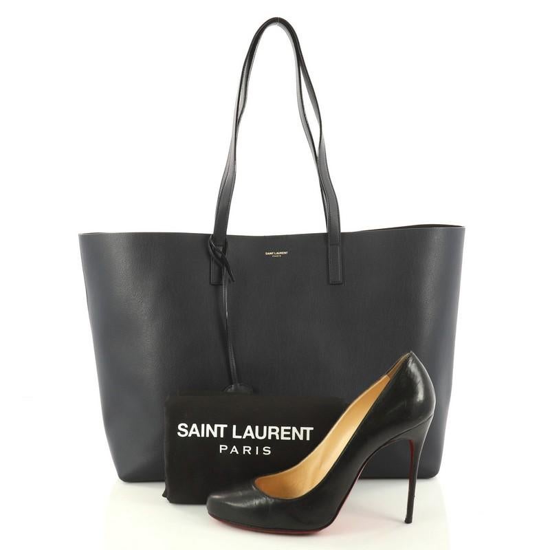 This authentic Saint Laurent Shopper Tote Leather Large showcases the brand's sleek and contemporary design perfect for everyday use. Crafted from navy leather, this versatile tote features dual-flat leather handles, gold stamped logo at its center
