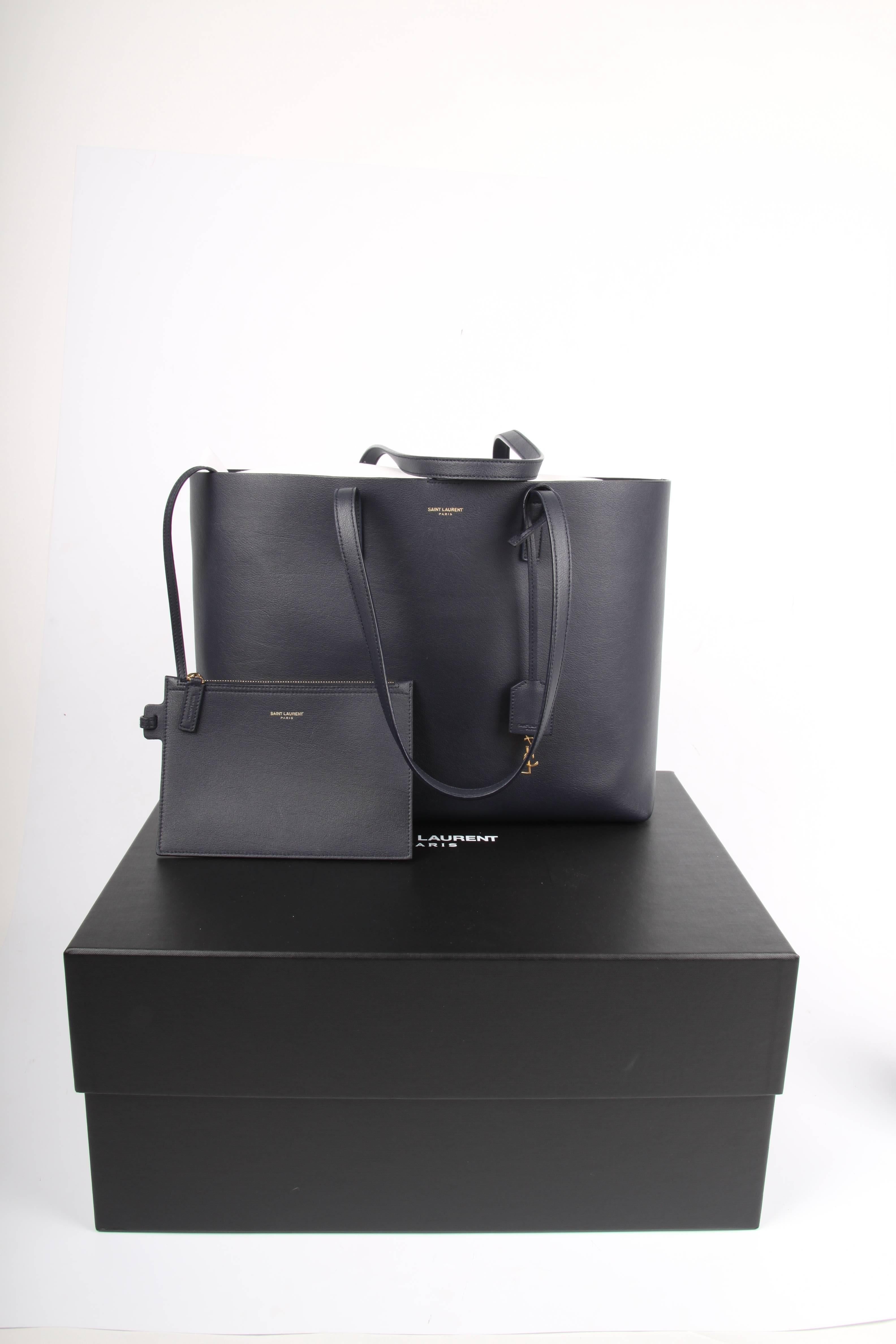 This bag is fantastic and sooo stylish! Dark blue calfskin leather shopper by Saint Laurent.

A rather large size with flat leather handles which can easily be worn on the shoulder. On one of the handles a so-called clochette is attached, it holds a