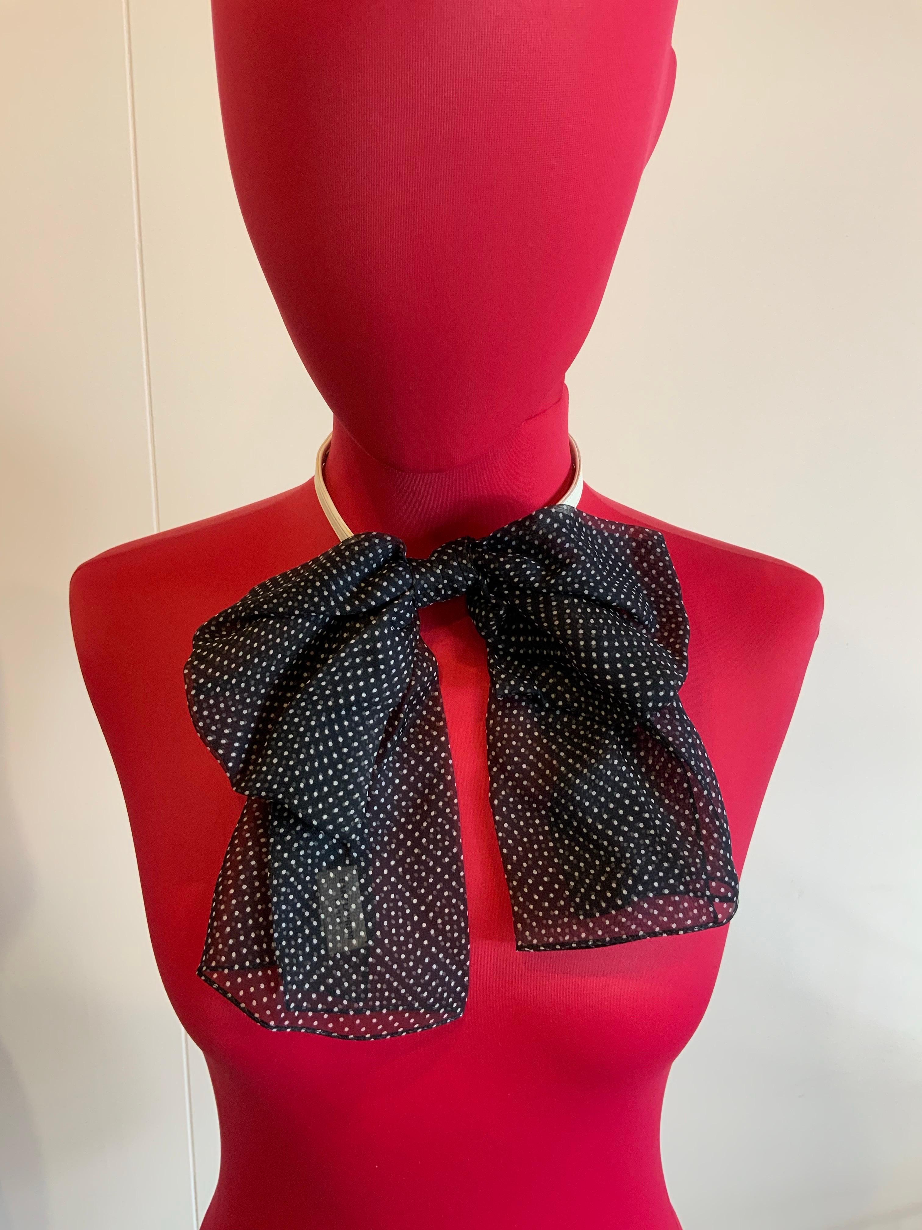 Saint Laurent neck bow 
in black silk with small white polka dots. 
White leather neck strap with an adjustable elastic part.
Has a small stain on the elastic (as shown in the photo)
Strap measurements: minimum length 37 cm
Excellent condition, like