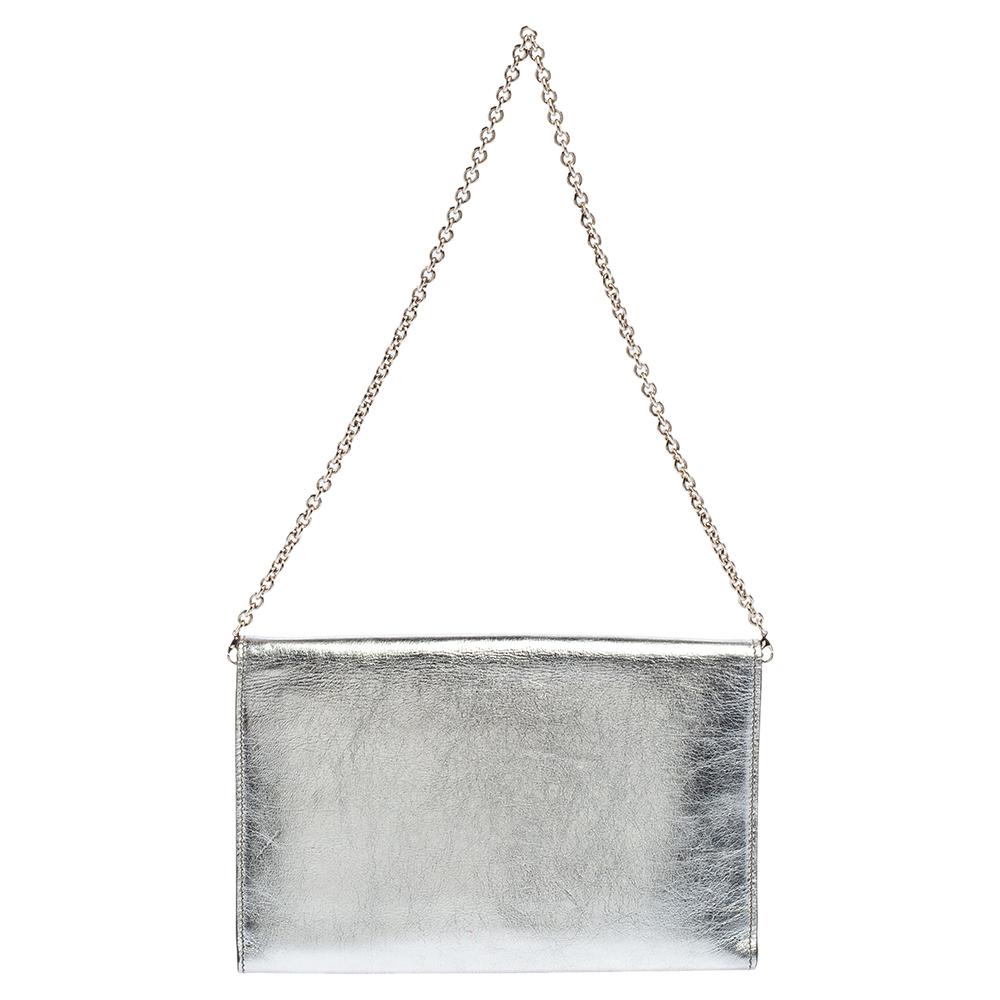 This Saint Laurent clutch is crafted from silver leather. It has a simple silhouette and features a logo detailing on the front flap. With a fabric and leather interior, the clutch houses a zip pocket and multiple card slots. It is held by a