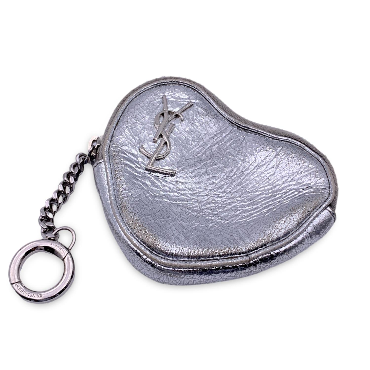 Saint Laurent Heart coin purse. Silver metal leather with YSL logo o the front. Upper zipper closure. keychain. 'Saint Laurent Paris' embossed inside

Details

MATERIAL: Leather

COLOR: Silver

MODEL: n.a.

GENDER: Women

COUNTRY OF MANUFACTURE: