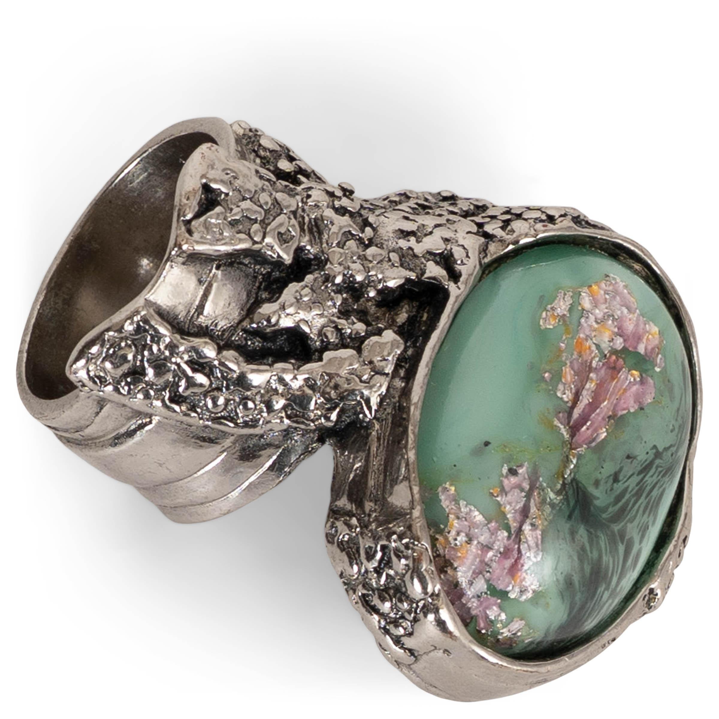 Cette bague Artis, 100% authentique, est réalisée en métal argenté et présente un design sculptural caractéristique. La bague présente un grand cabochon ovale en verre vert menthe avec des veines marbrées uniques et de subtils détails irisés.