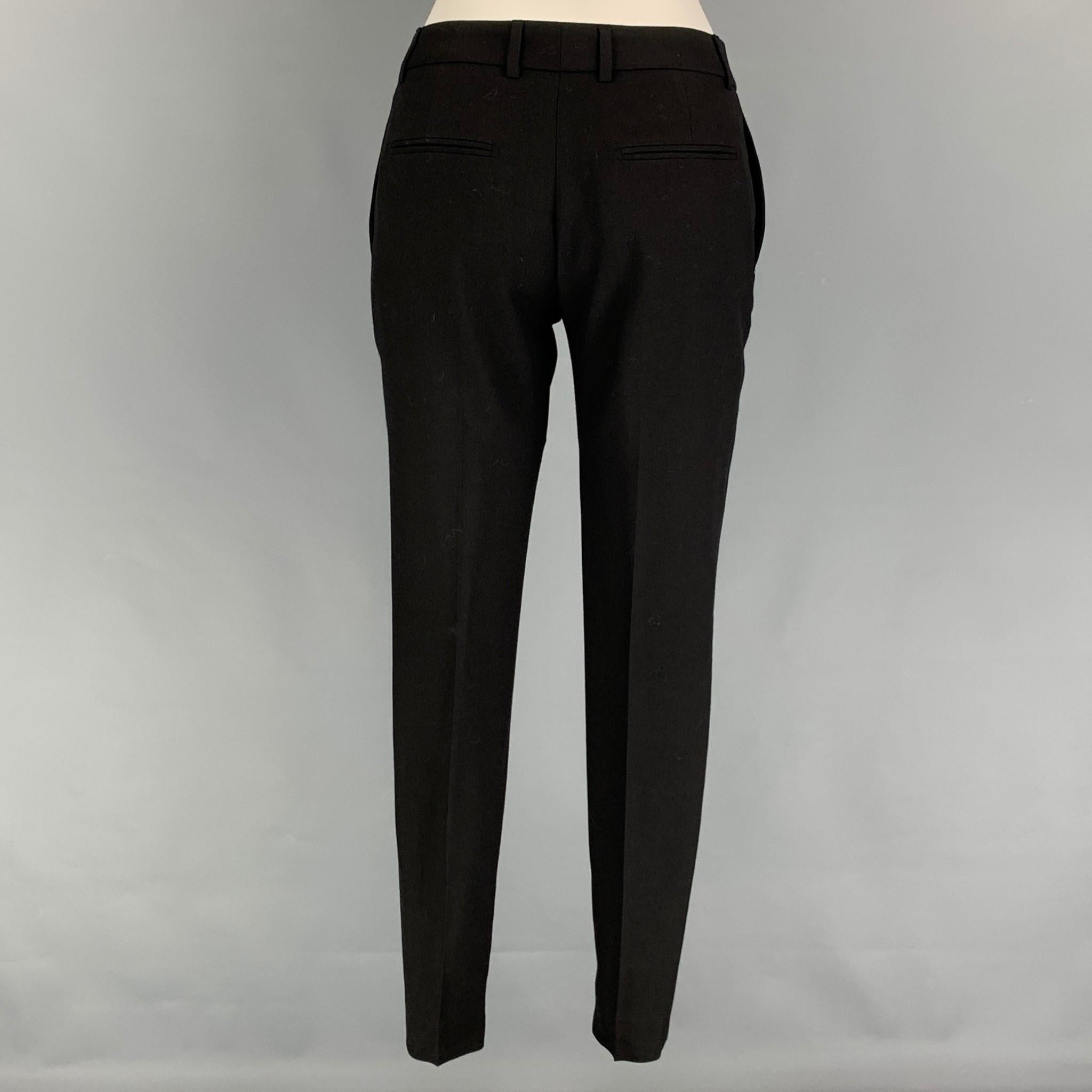 SAINT LAURENT dress pants comes in a black virgin wool featuring a skinny fit, flat front, zipped legs, front tab, and a zip fly closure. Made in Italy. 

Very Good Pre-Owned Condition.
Marked: F 34
Original Retail Price: