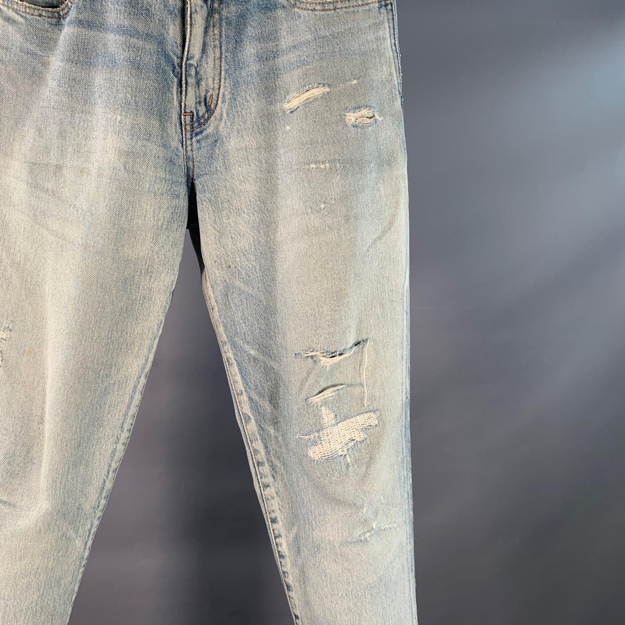 Jean SAINT LAURENT en denim de coton bleu avec un style vieilli, une jambe fuselée et une fermeture à glissière. Fabriqué au Japon. Très bon état. Marque mineure. 

Marqué :   31 

Mesures : 
  Taille : 31 pouces Élévation : 9.5 pouces Entrejambe :