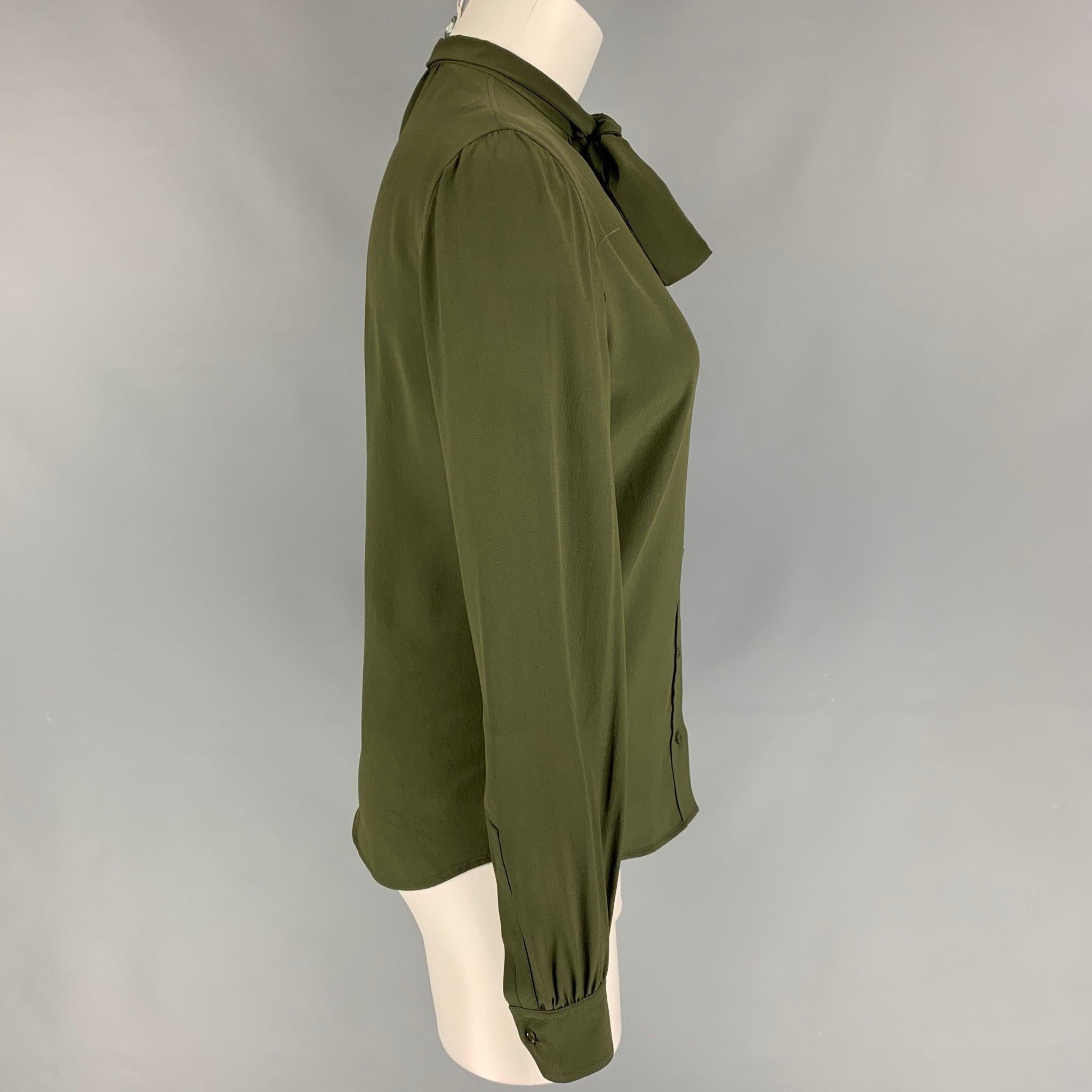SAINT LAURENT blouse comes in a dark green silk featuring a front bow design, long sleeves, and a buttoned closure. Made in Italy. 

Excellent Pre-Owned Condition.
Marked: F 36

Measurements:

Shoulder: 16 in.
Bust: 34 in.
Sleeve: 25 in.
Length: