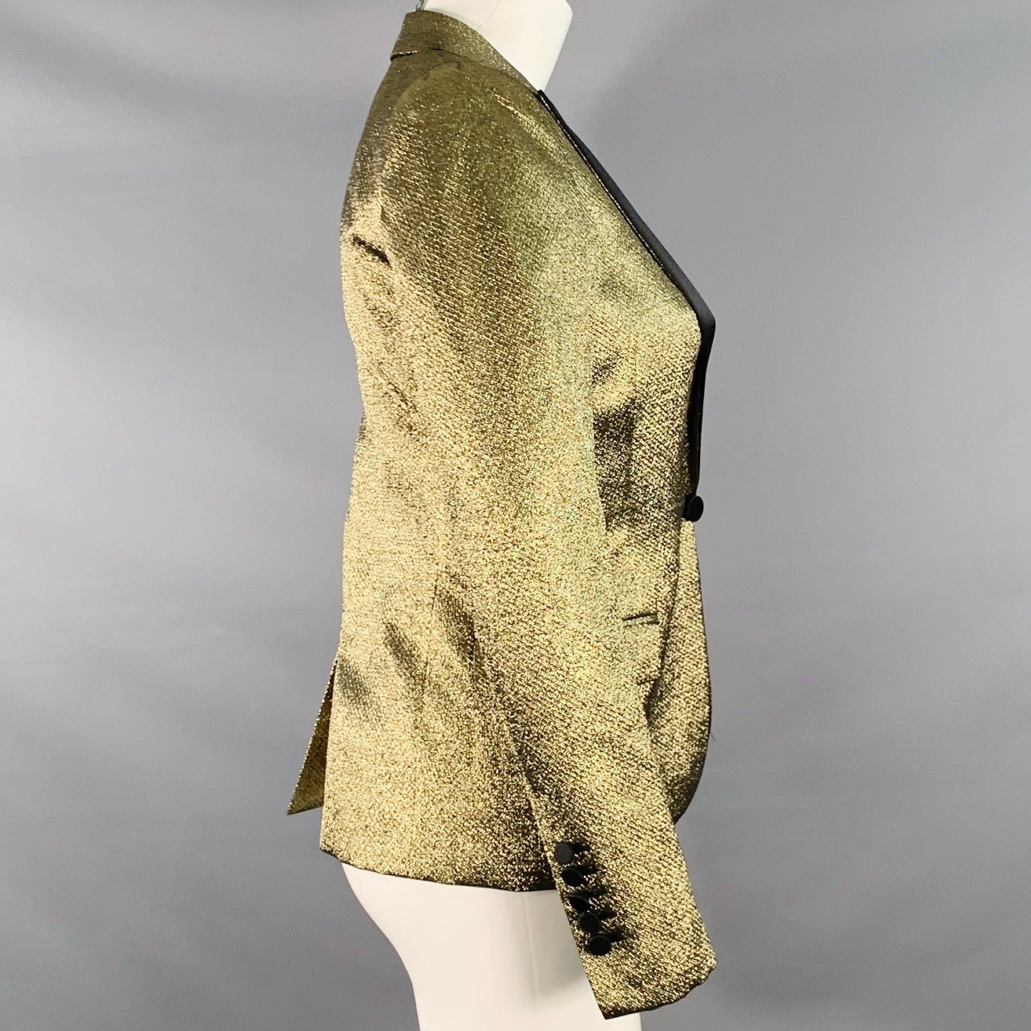 Blazer SAINT LAURENT
en polyester mélangé de couleur or métallisé, avec un revers en satin noir contrastant, un dos ventilé et une fermeture à crochets et œillets avec détails de boutons. Fabriqué en Italie. Excellent état. 

Marqué :   FR 36