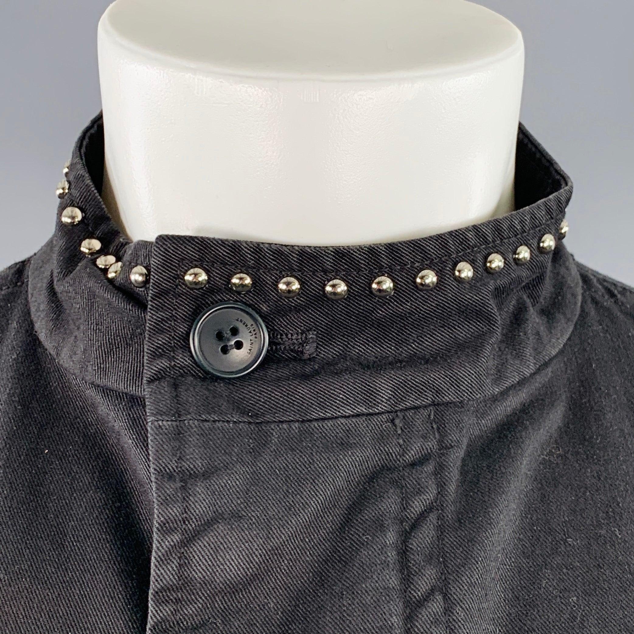 SAINT LAURENT coat
in a black cotton woven twill featuring a silver tone metal studded design at neck and pockets, two flap pockets with snaps, and zip & snaps closure. Made in Japan.Excellent Pre-Owned Condition. 

Marked:   M 

Measurements: 
