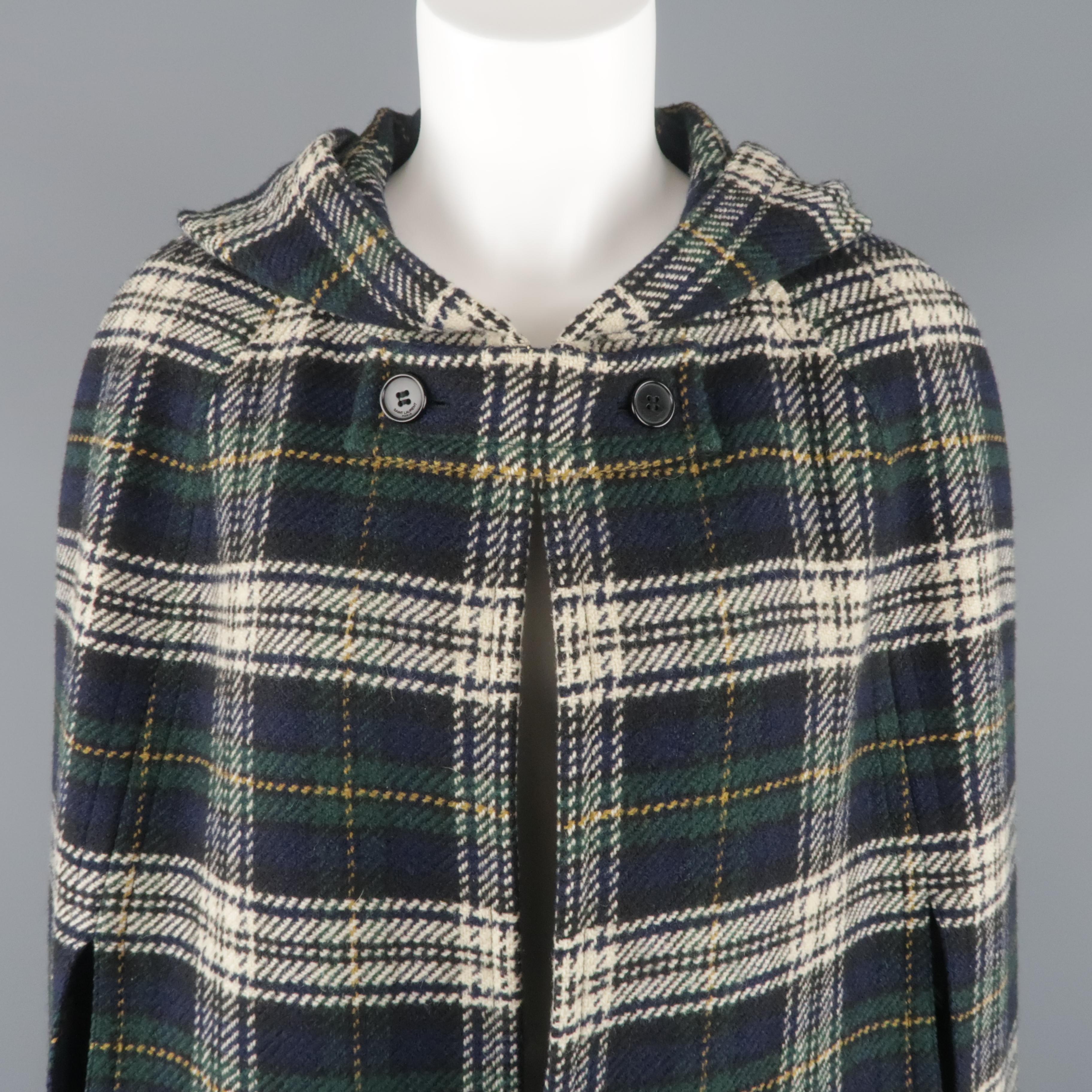 SAINT LAURENT cape comes in navy and green wool plaid with cream and gold accents with a tab closure at neckline, arm slits, and hood. Made in Italy.
 
Excellent Pre-Owned Condition.
Marked: FR 40
 
Measurements:
 
Shoulder: 19 in.
Bust: 58