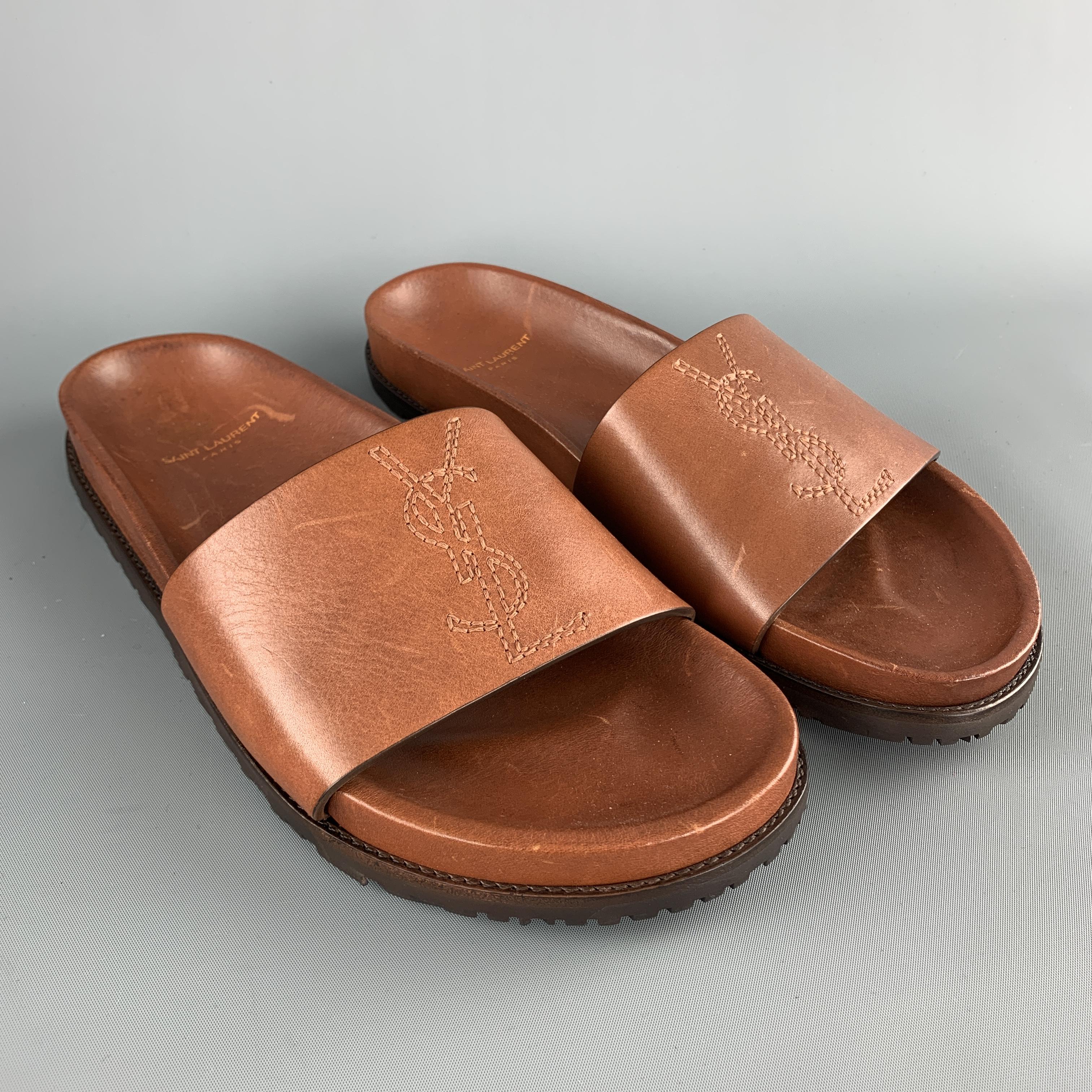 SAINT LAURENT slide sandals come in tan cognac leather with a thick YSL logo embroidered strap. Brand new with minor imperfections from storage. As-is. Made in Italy.

New in Box.
Marked: IT 41

Measurements:

Outsole: 11 x 4.25 in.