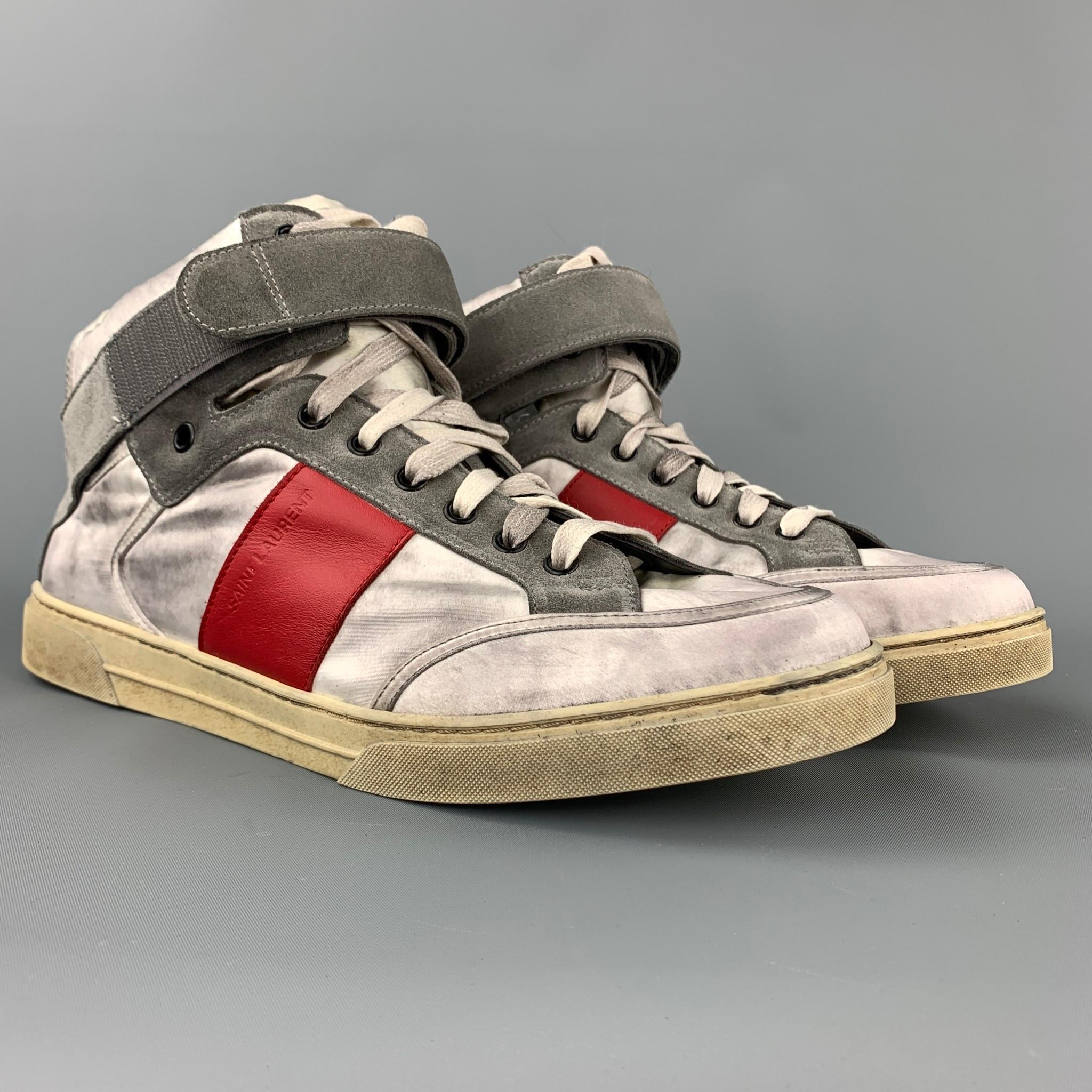 SAINT LAURENT sneakers comes in a silver distressed leather with a red trim featuring a high top style, hook and loop detail, rubber sole, and a lace up closure. Moderate wear. Made in Italy.

Good Pre-Owned Condition.
Marked: M 533635