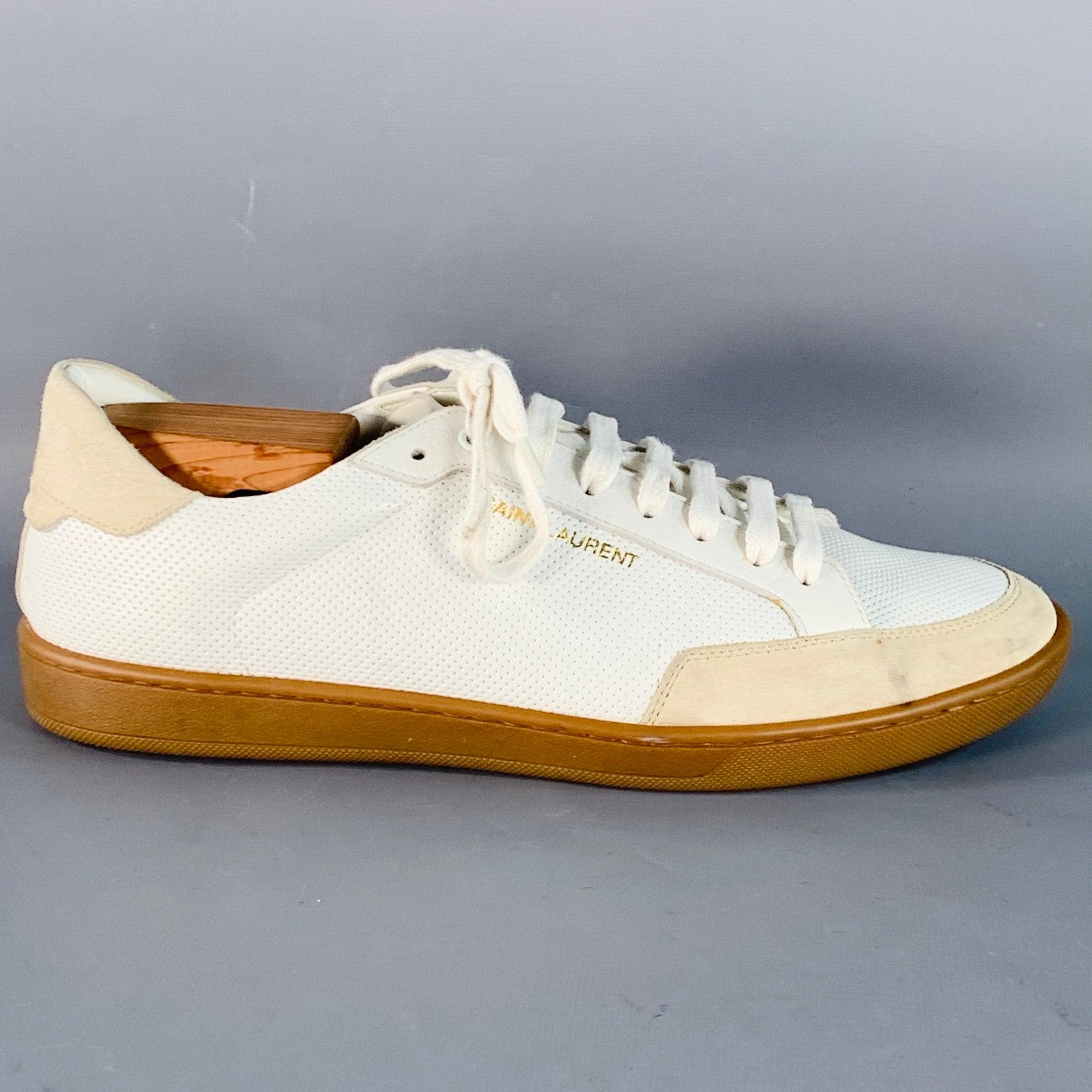 Zapatillas SAINT LAURENT
en piel blanca con dibujo perforado, ribete de ante beige y cierre de cordones. Zapateros no incluidos. Made in Italy. Buen estado de conservación. Algunas grietas en la apertura de la zapatilla izquierda. 

Marcado:   DE