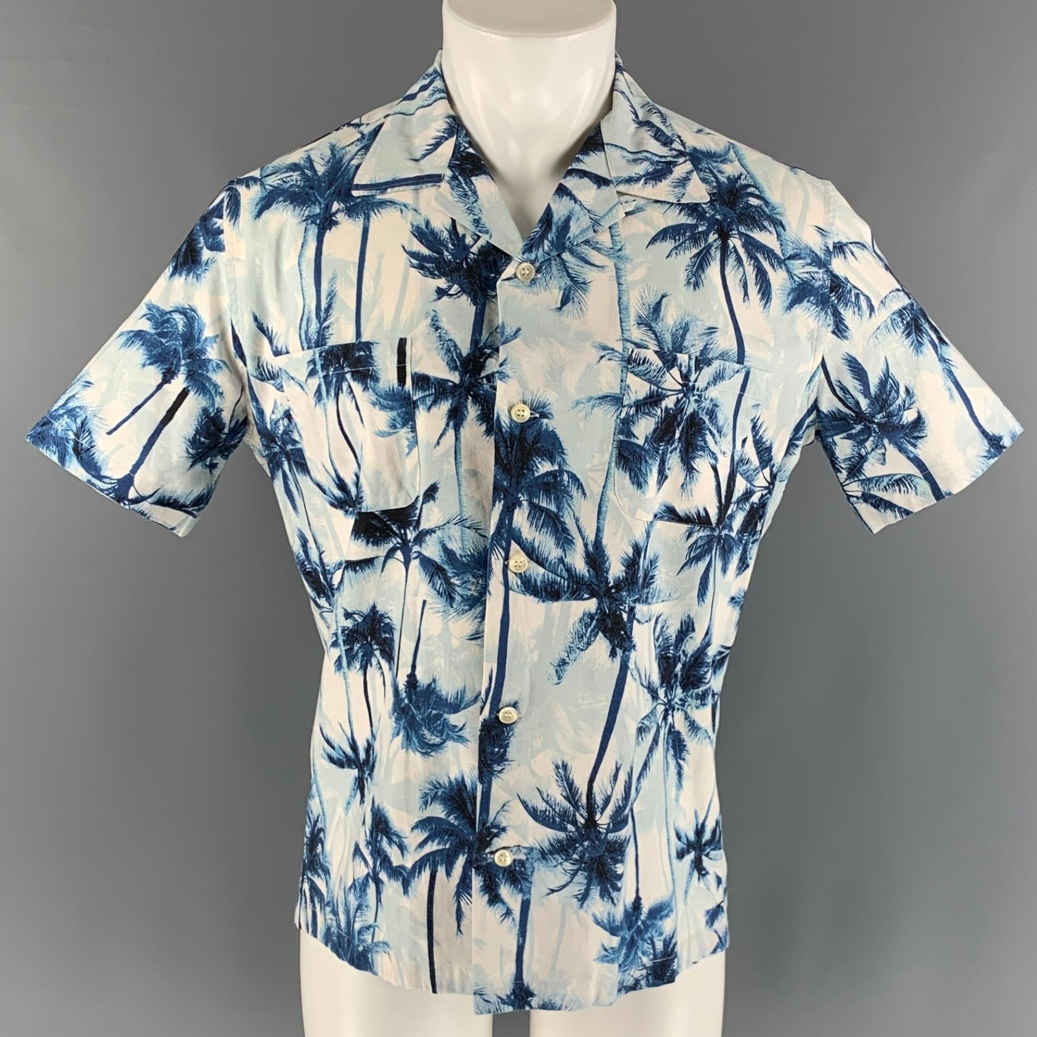 SAINT LAURENT short sleeve shirt comes in a blue & white palms print motif cotton woven material featuring a camp collar, patch pockets, and a button up closure. Made in Italy.

Very Good Pre-Owned Condition.
Marked: 40 15