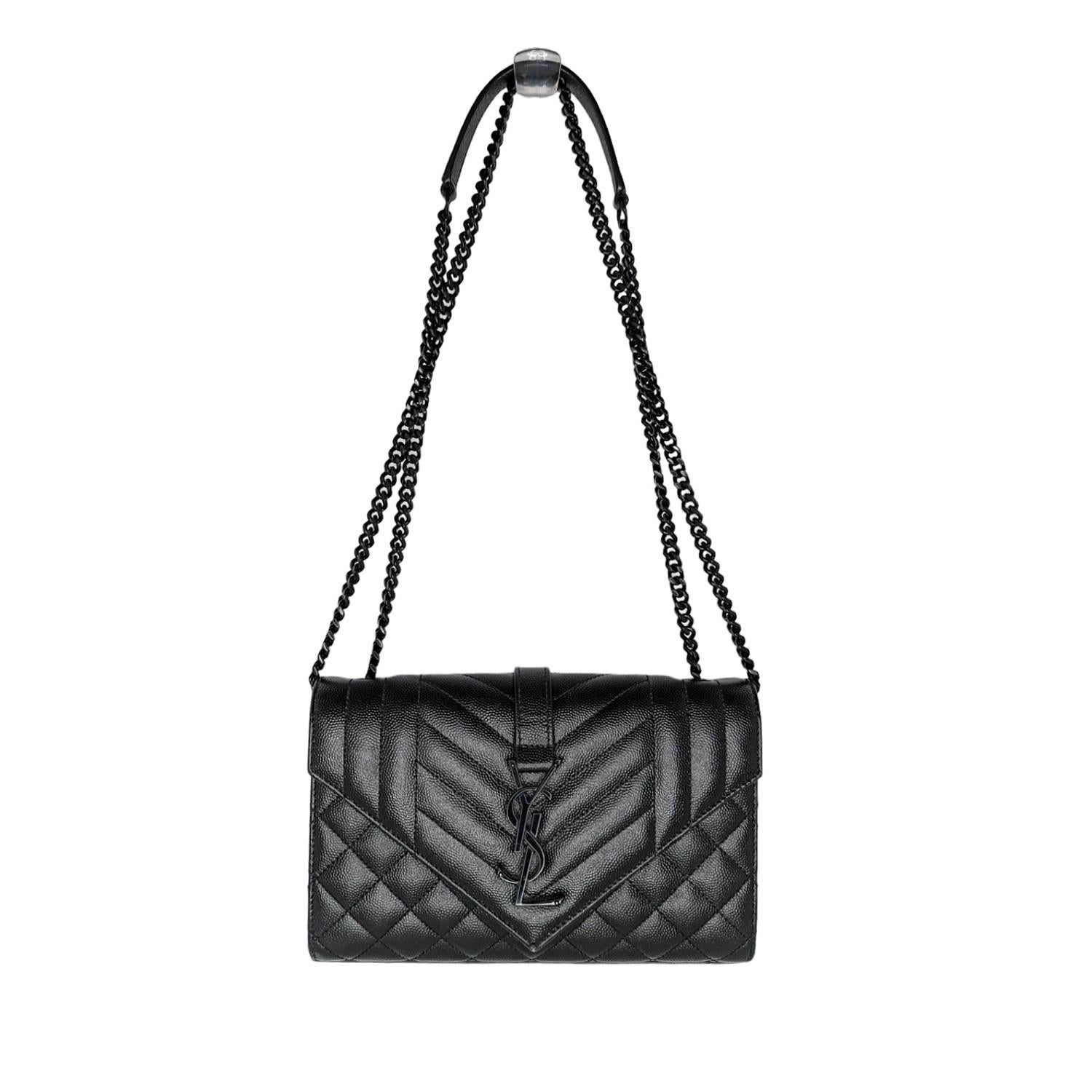 This elegant shoulder bag is crafted of grained leather in black with chevron, linear, and diamond quilting. The bag features a large exterior flat pocket, black chain-link shoulder straps with a leather shoulder pad and an envelope style flap with