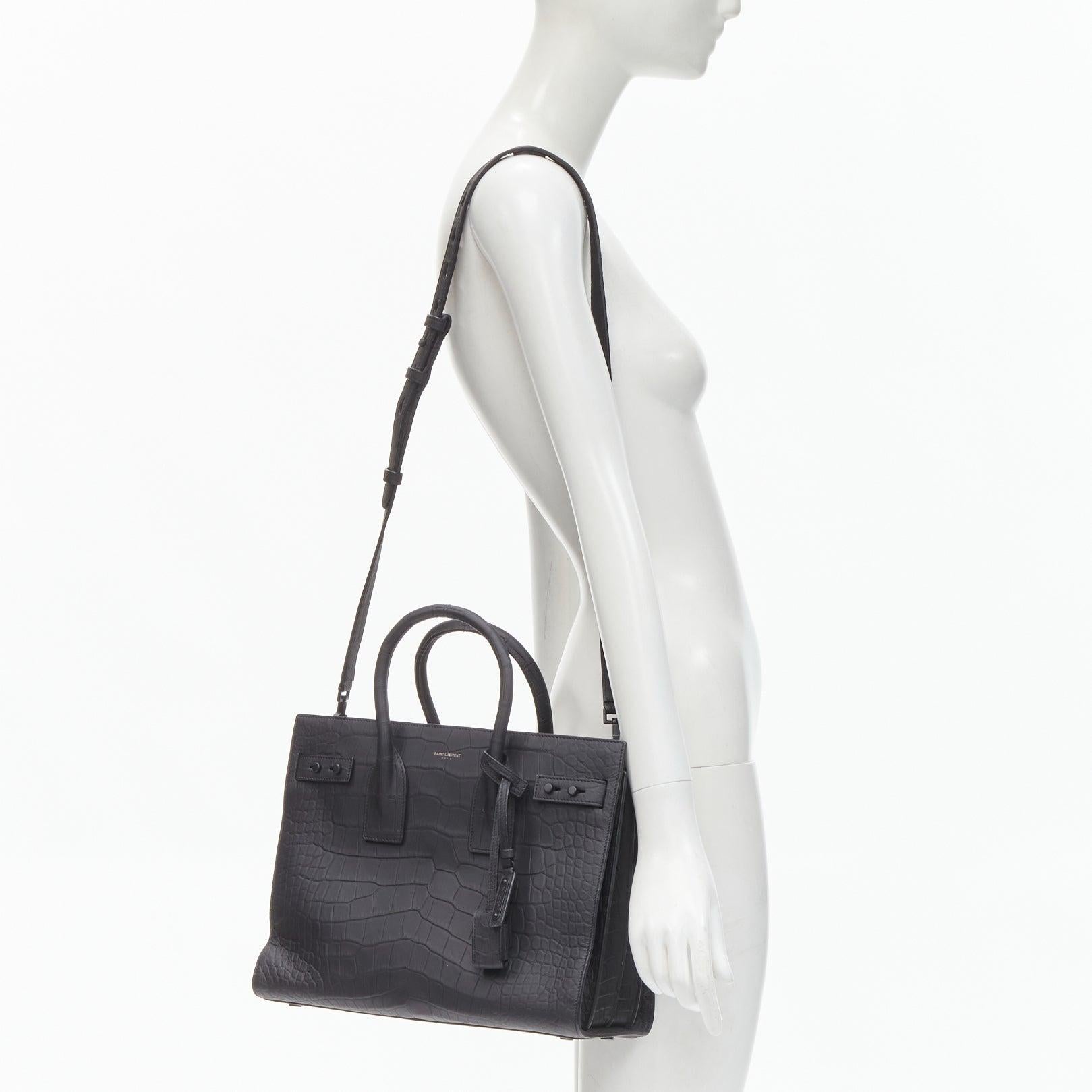 SAINT LAURENT Small Sac De Jour matte black stamped croc tote bag
Reference: KNLM/A00238
Brand: Saint Laurent
Designer: Anthony Vaccarello
Model: Sac De Jour Small
Material: Leather
Color: Black
Pattern: Solid
Closure: Open Top
Lining: 