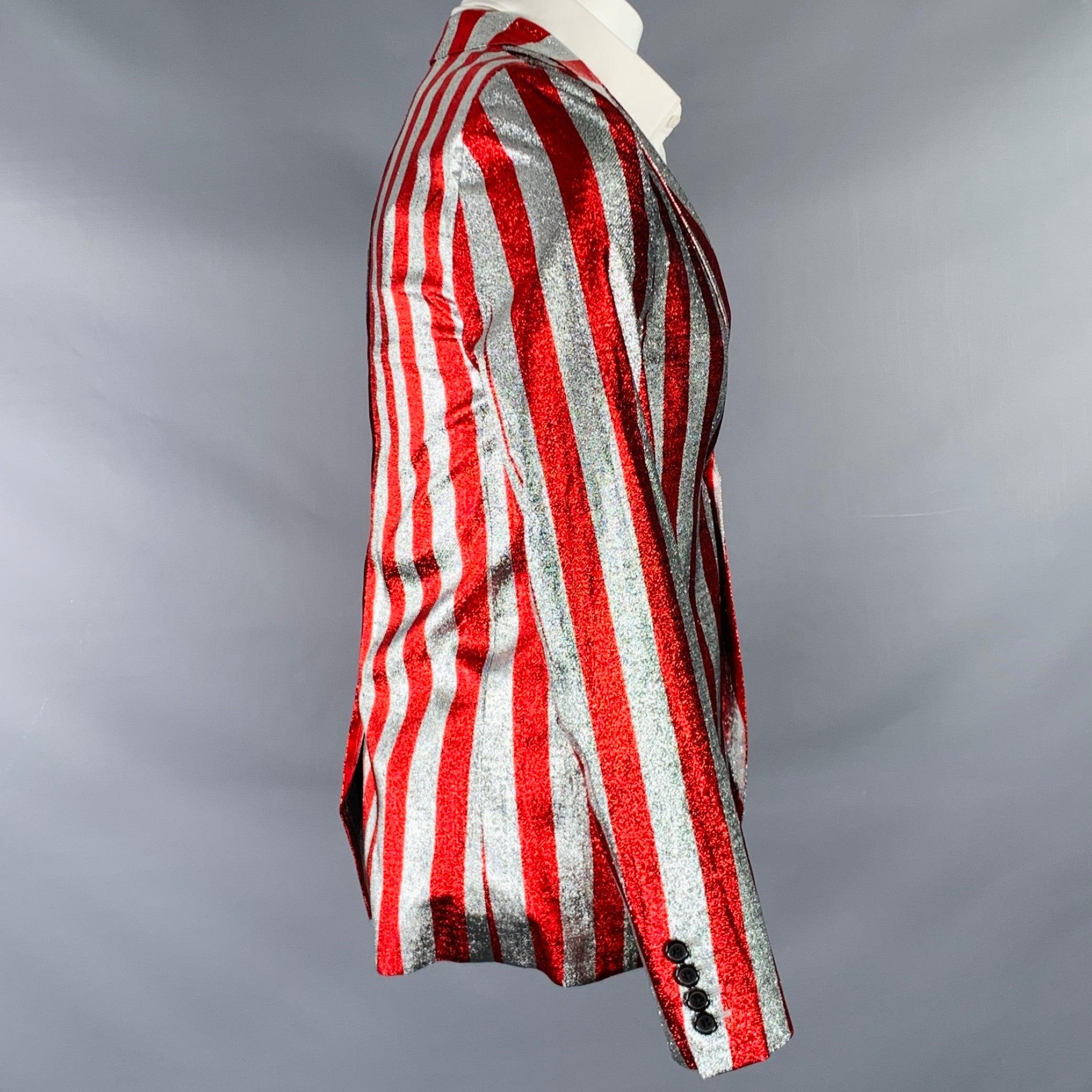 Cappotto sportivo Saint Laurent SS15
in un tessuto scintillante di misto viscosa rosso e argento con motivo a righe verticali, rever a lancia, spacco posteriore e chiusura a due bottoni. Made in Italy. Eccellente condizione di usato. 