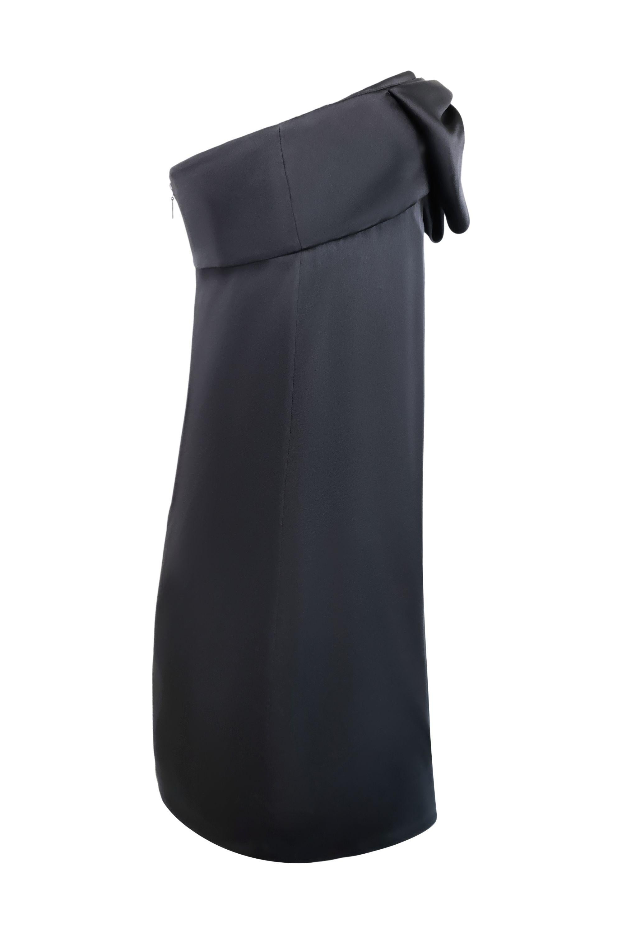 This Saint Laurent strapless mini dress is the perfect LBD. Crafted from luxurious black satin, the dress features a simple yet sophisticated silhouette, gently draping the body for a flattering fit. Its standout detail is the oversized bow at the