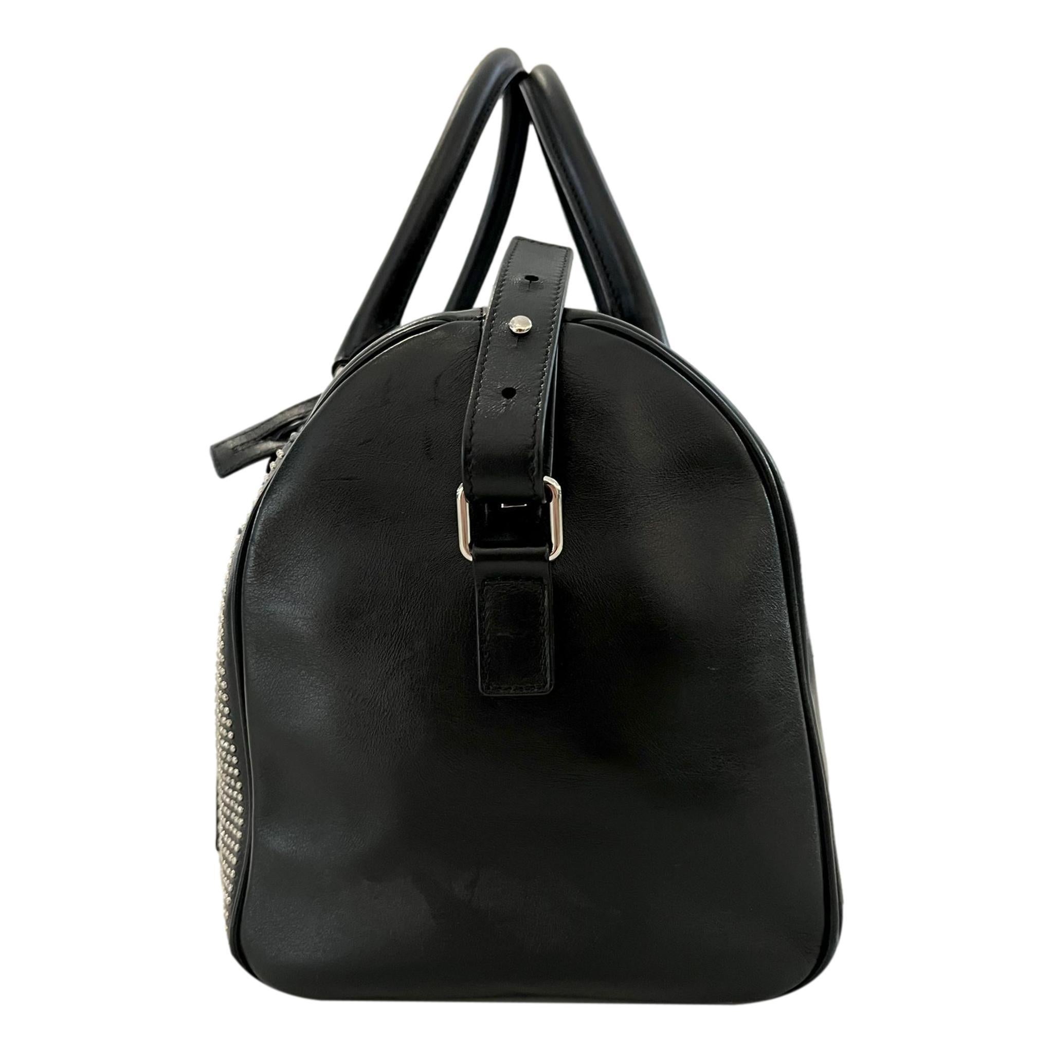 Saint Laurent Studded Leather Duffle Bag

Black bag crafted from calfskin leather and studded with miniature silver studs.

Featuring rolled leather top handles and optional leather shoulder strap.

Detailed with branded, silver hardware and
