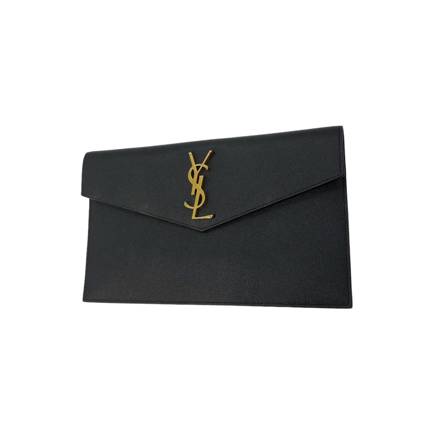 This Saint Laurent Uptown Envelope Pouch was made in Italy and it is finely crafted of black leather with a gold-tone hardware 'YSL' logo. It has a fold over magnetic closure that opens up to a black grosgrain interior.

Brand: Saint
