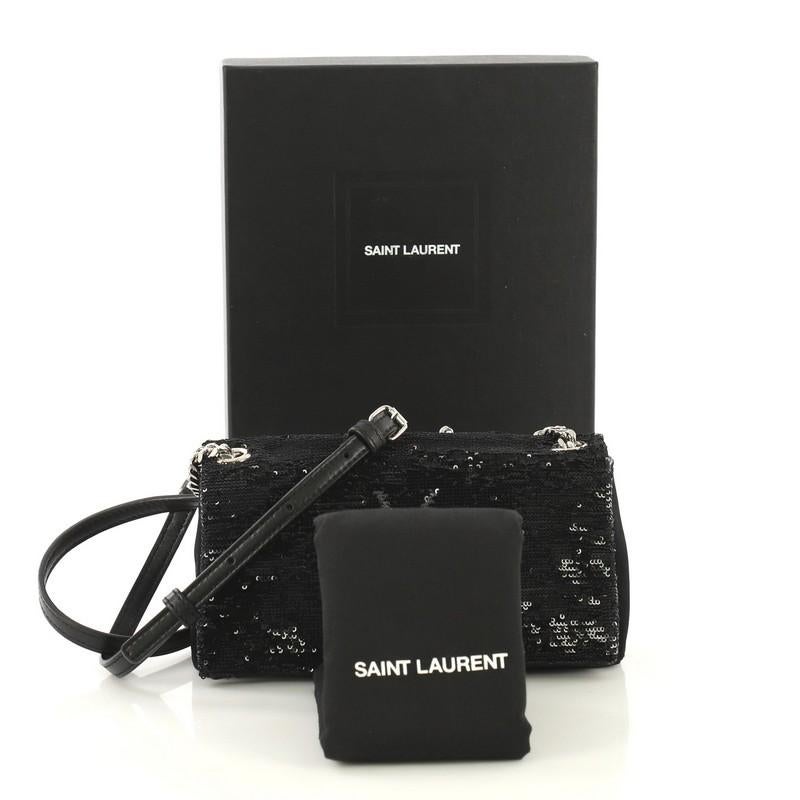 This Saint Laurent West Hollywood Crossbody Bag Sequins Toy, crafted in black sequins and suede, features an adjustable leather and chain shoulder strap, front flap with iconic YSL logo, and silver-tone hardware. Its magnetic snap button closure