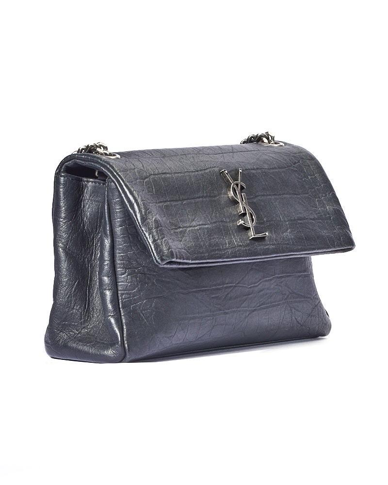 Borsa firmata Saint Laurent, modello West Hollywood nella misura medium, realizzata in morbida pelle nera con hardware argento. Dotata di una patta con classico logo del brand “YSL” in metallo e chiusura a bottone calamitato. Internamente rivestita