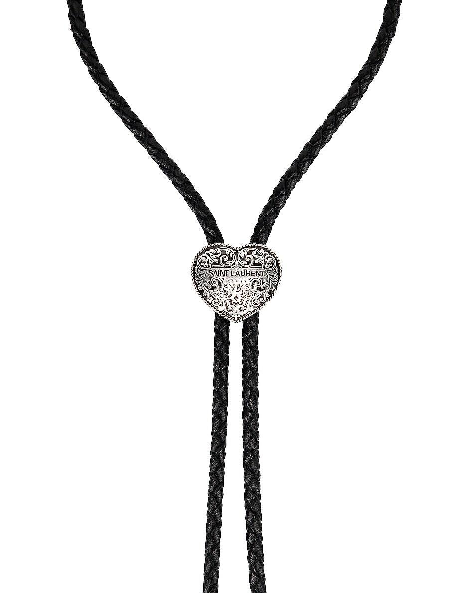 Saint Laurent Western Bolo Tie Silver-Tone Brass Heart-Shaped Slide Necklace

This black Saint Laurent heart clasp plaited leather bolo tie is expertly crafted in Italy from plaited black leather with silver-tone brass detailing at the ends. The
