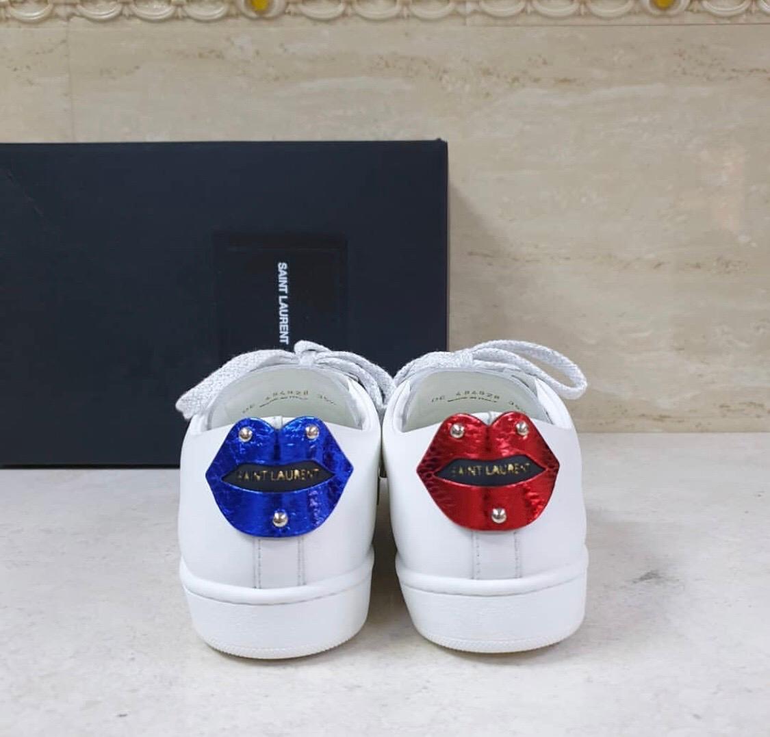 Saint Laurent’s cult Court Classic sneakers to feature red and blue snakeskin appliqué lips at the heel counter. Cut in a flattering low top silhouette, italian made with a lace-up front fastening with silver laces, logo branding at the tongue and