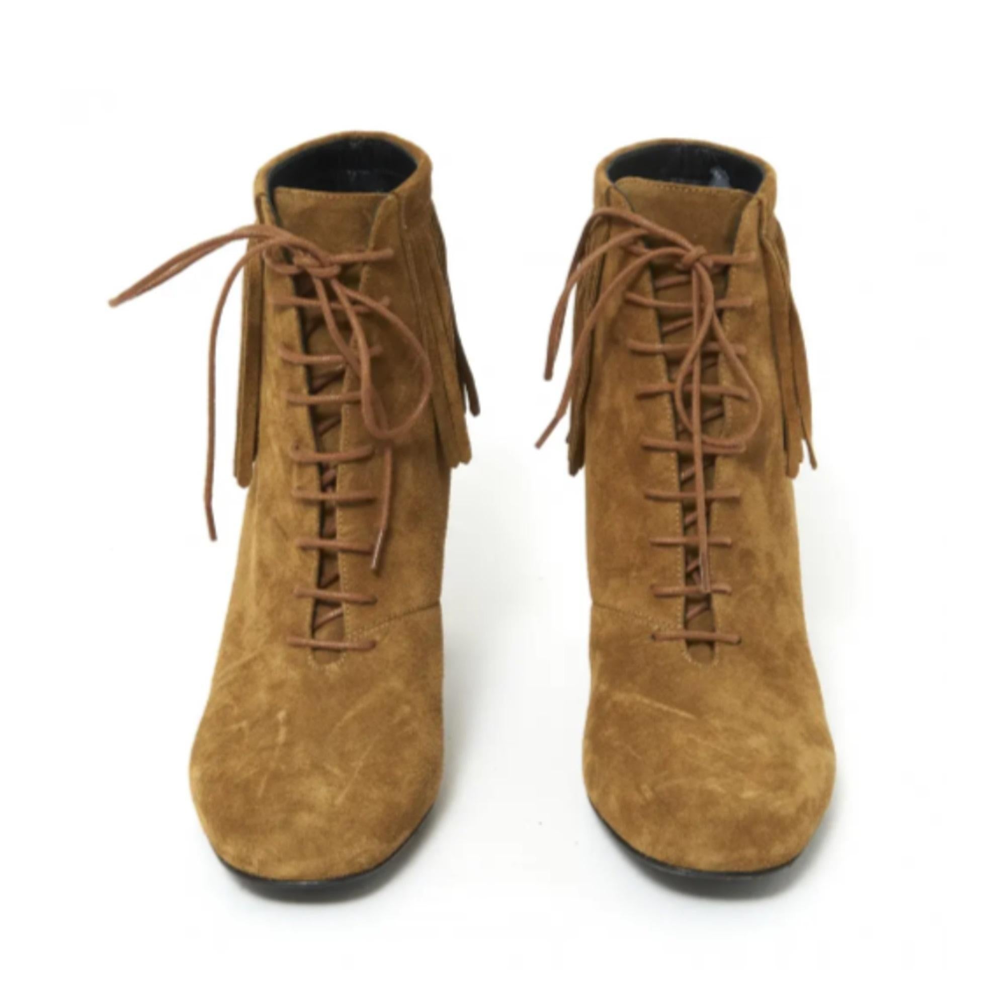 Bottes Saint Laurent en daim camel, lacées sur le devant et décorées de franges tout autour de la cheville, talon haut recouvert de daim. Taille 38,5FR ou UK5,5 et US8, talon de 8,5 cm, semelle intérieure de 24,7 cm. Les bottes n'ont été portées