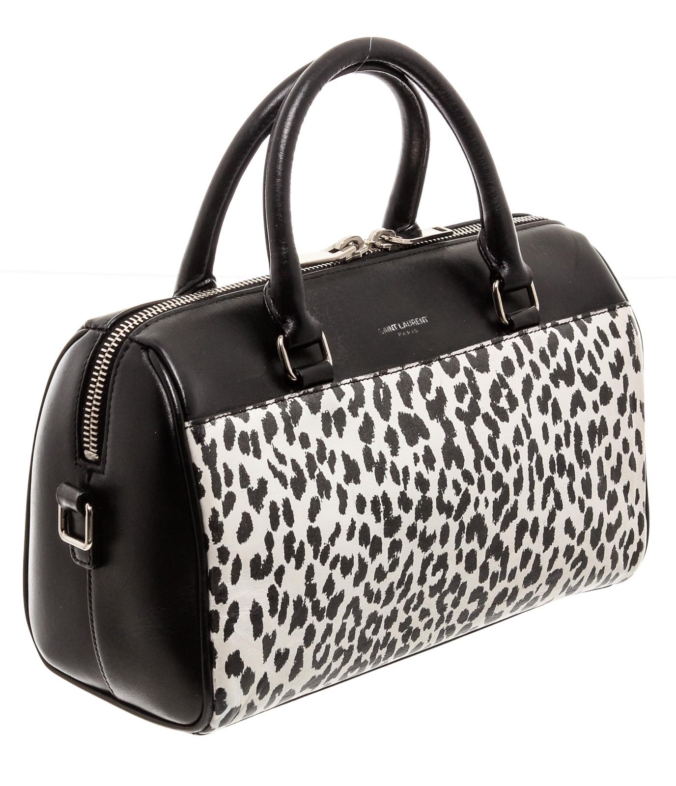 Black and white Cheetah print leather Saint Laurent YSL Classic Baby Duffle bag with silver-tone hardware, dual rolled top handles, foil-stamped logo at front, protective feet at base, tonal suede interior lining and zip closure at top. Detachable
