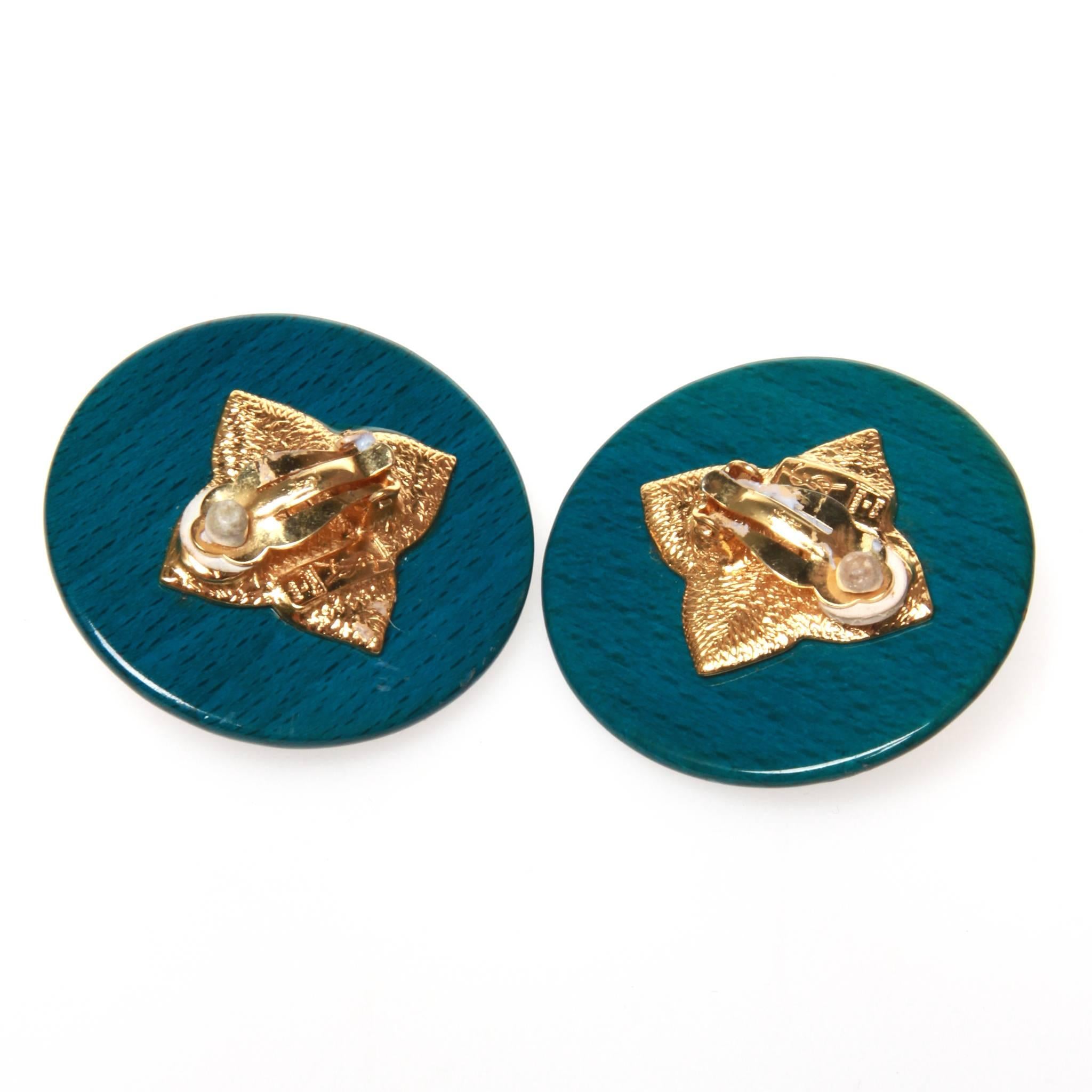 Vintage Yves Saint laurent clip-on earrings featuring a gold-tone metal flower set on a disc of mottled blue resin. YSL stamped at back. 