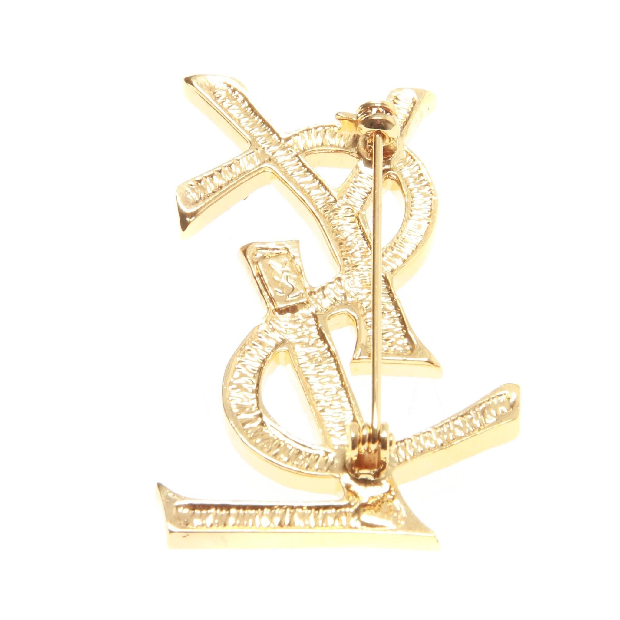 Iconic vintage monogram brooch featuring a Swarovski crystals set in a gold-plate setting. 

Engraved YSL. 

Circa 80s 