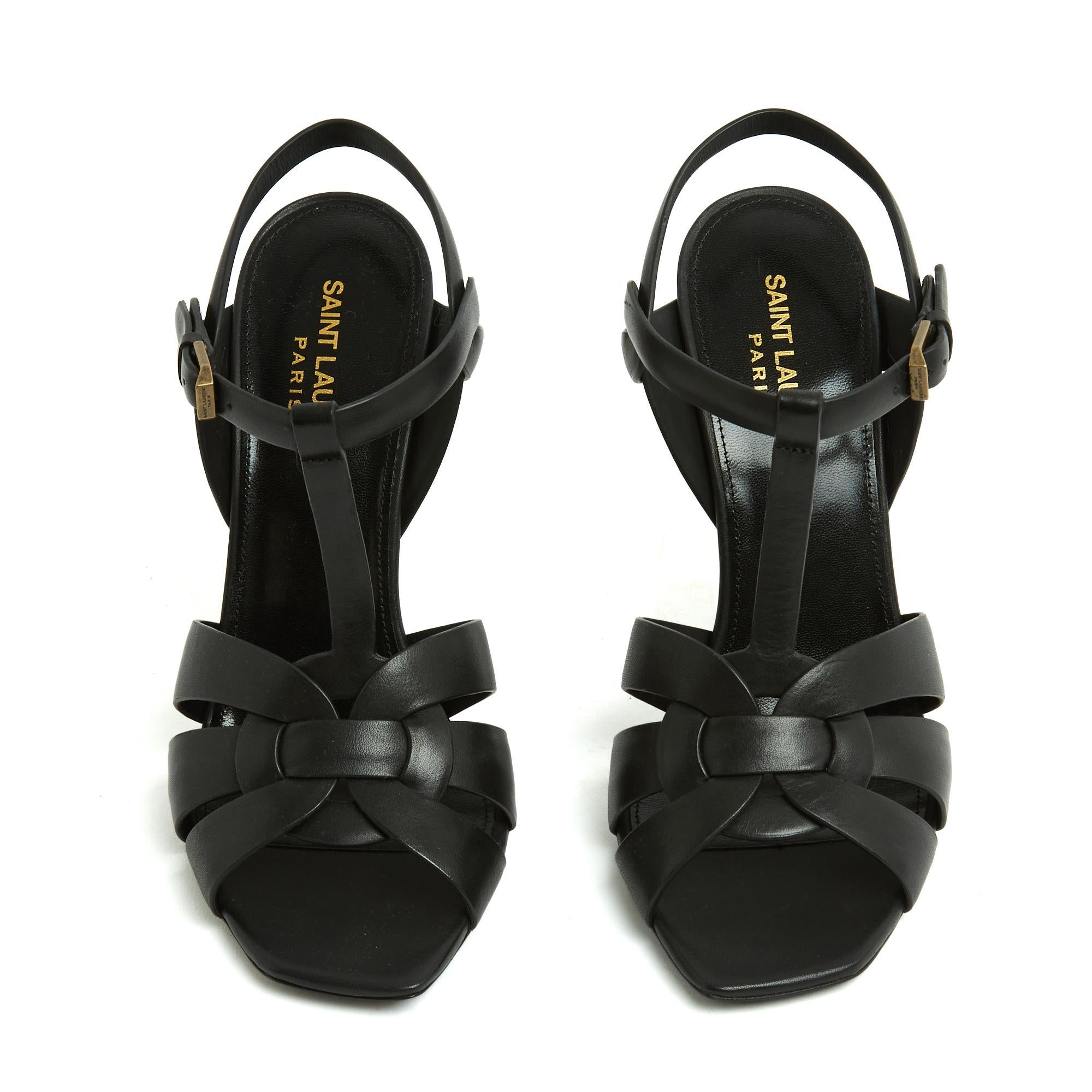Saint Laurent Nouvelles Tribute sandals in black leather, covered stiletto heel, crisscrossed straps and strap with Saint Laurent Paris pin buckle on the ankle. Size 38FR or UK5 and US7.5: 11.5 cm heel (- 1 cm sole), 24.4 cm insole. The sandals are